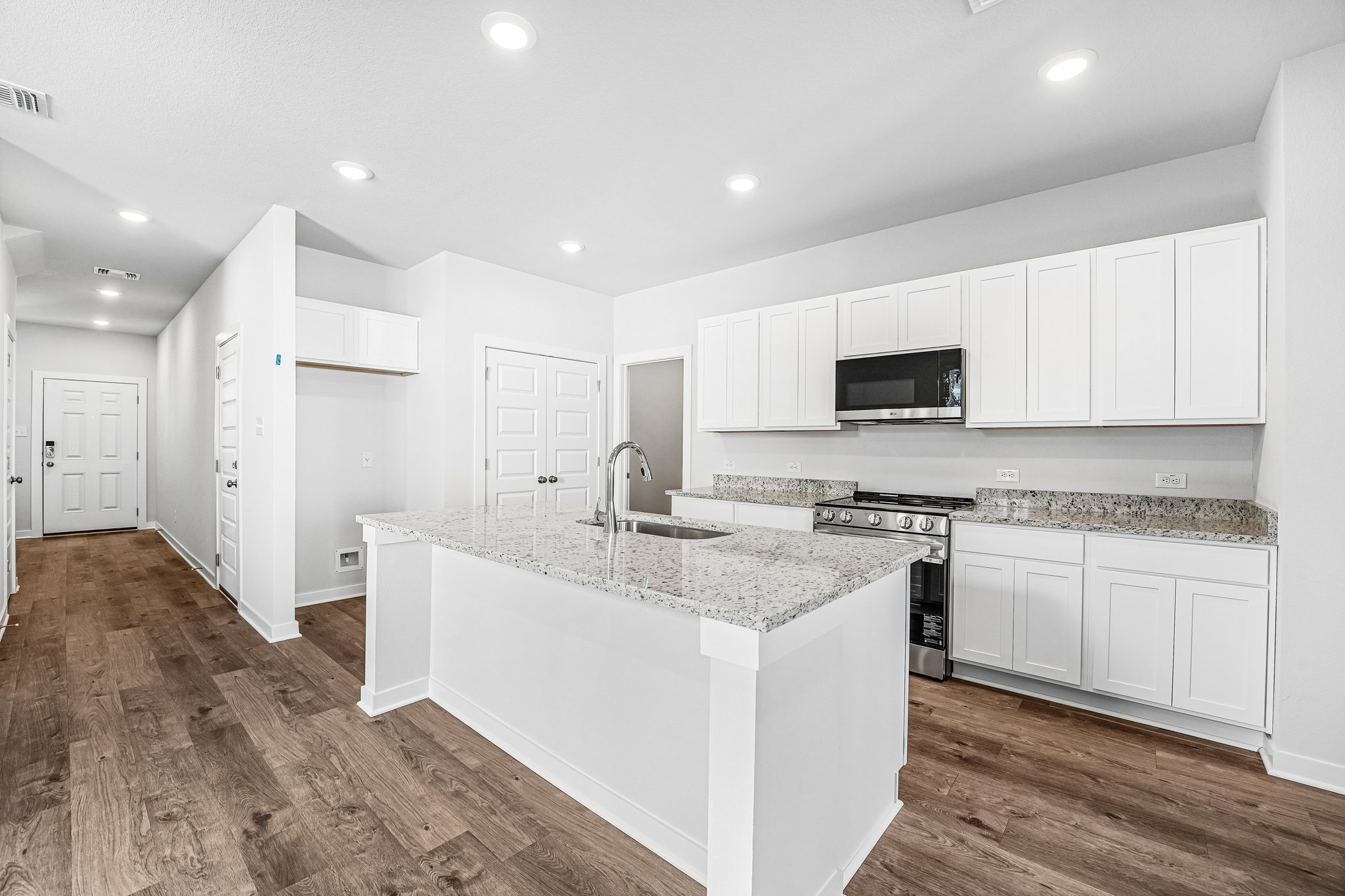 A kitchen with white cabinets.