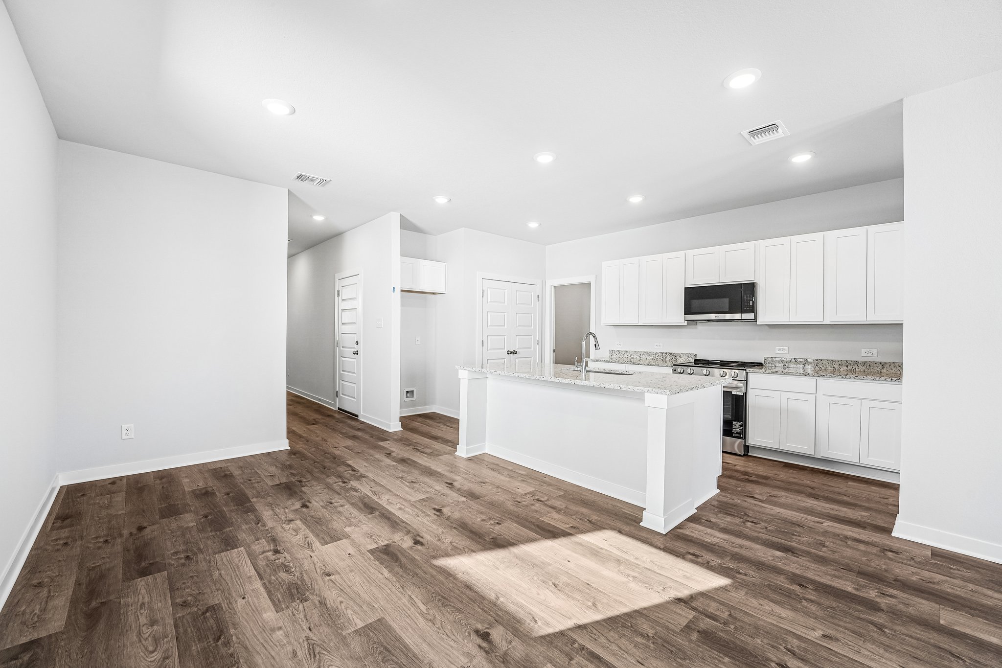 A kitchen with white cabinets.