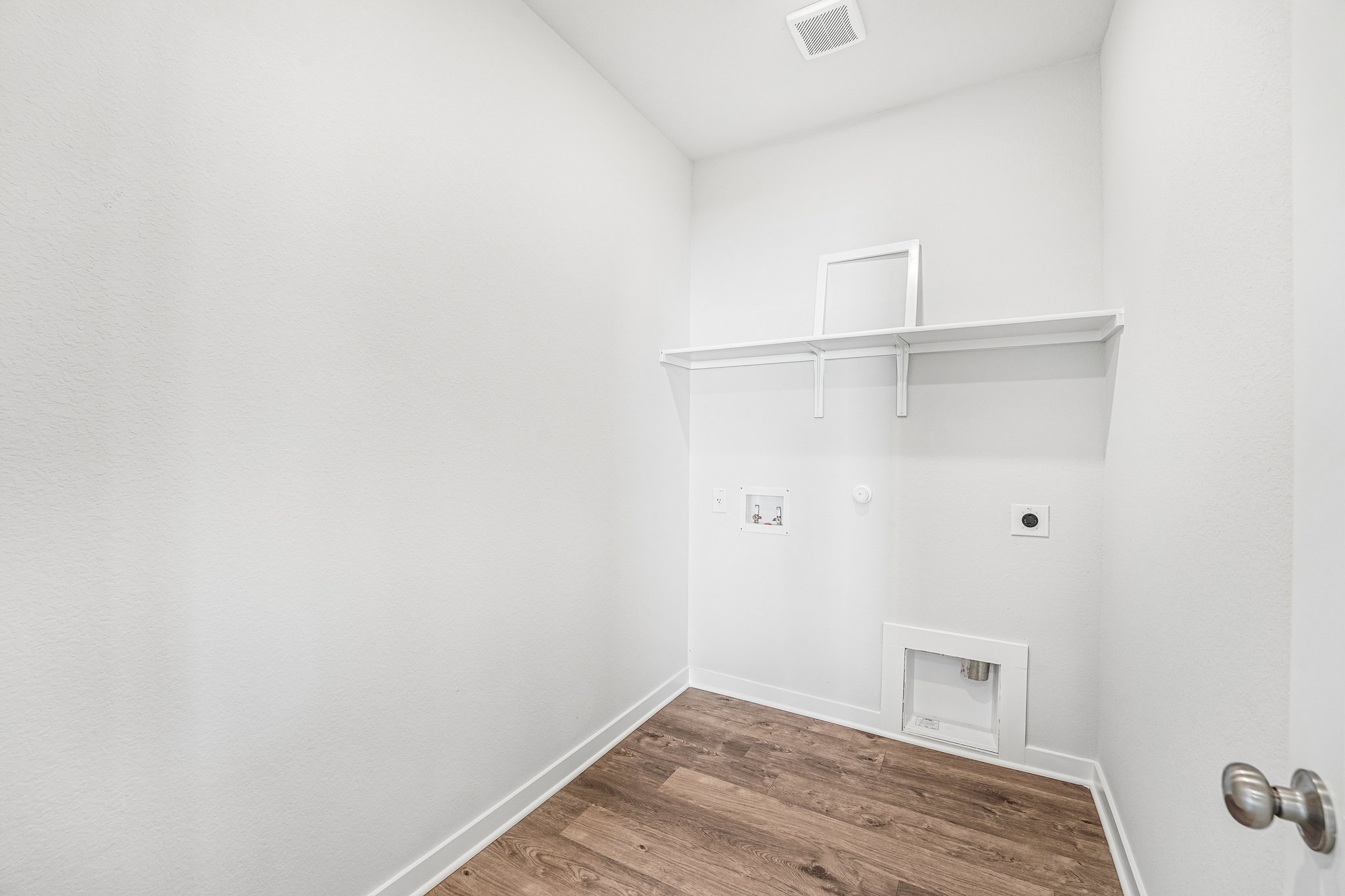 A white room with a wood floor.