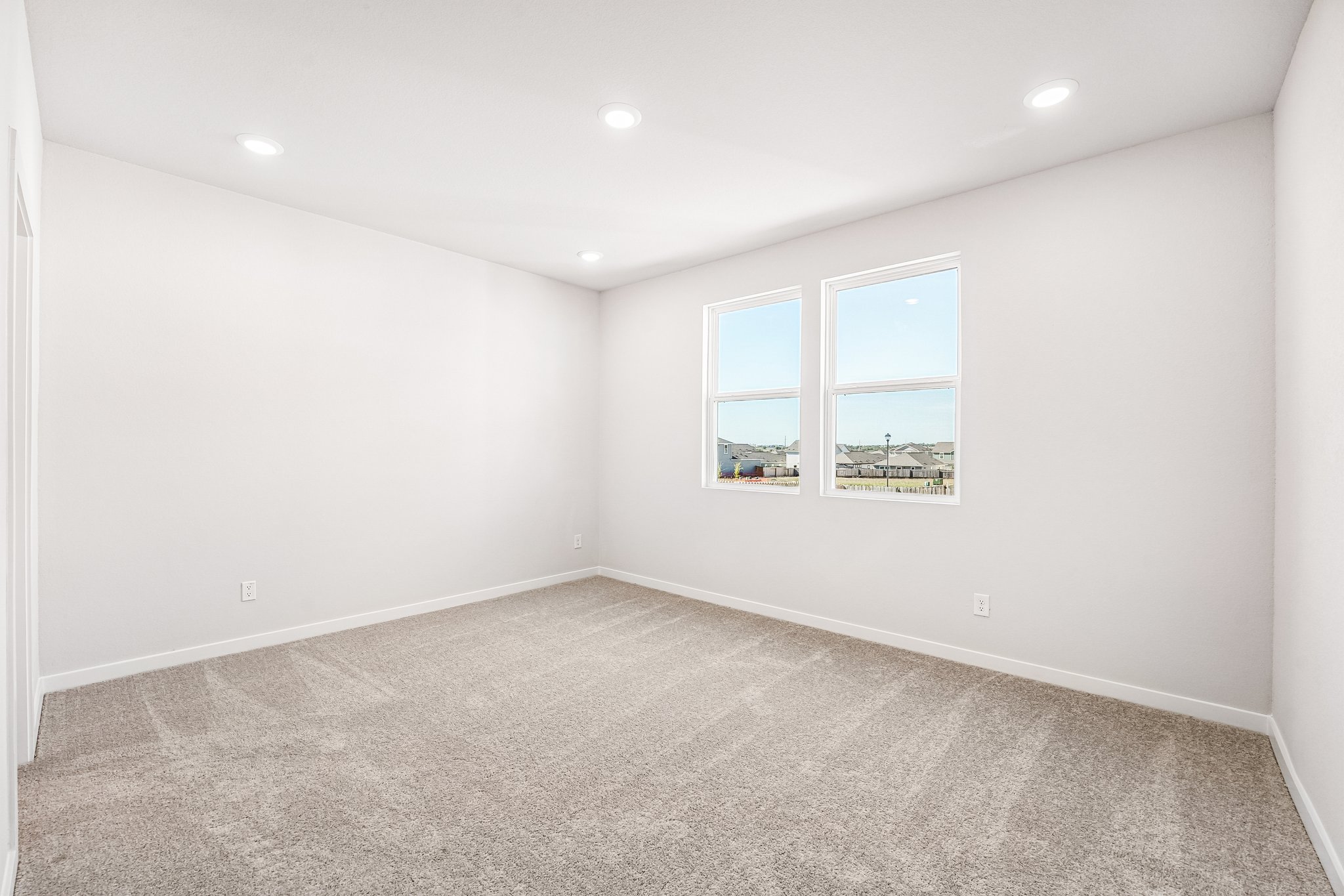 A room with a window and a carpet.
