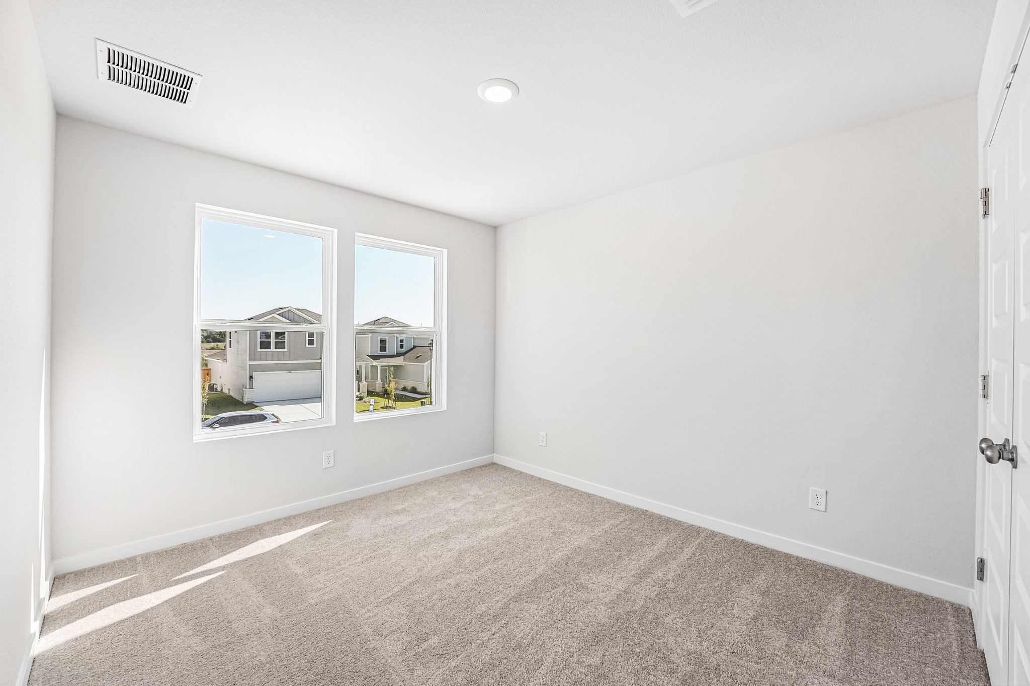 A room with a window and a carpet.