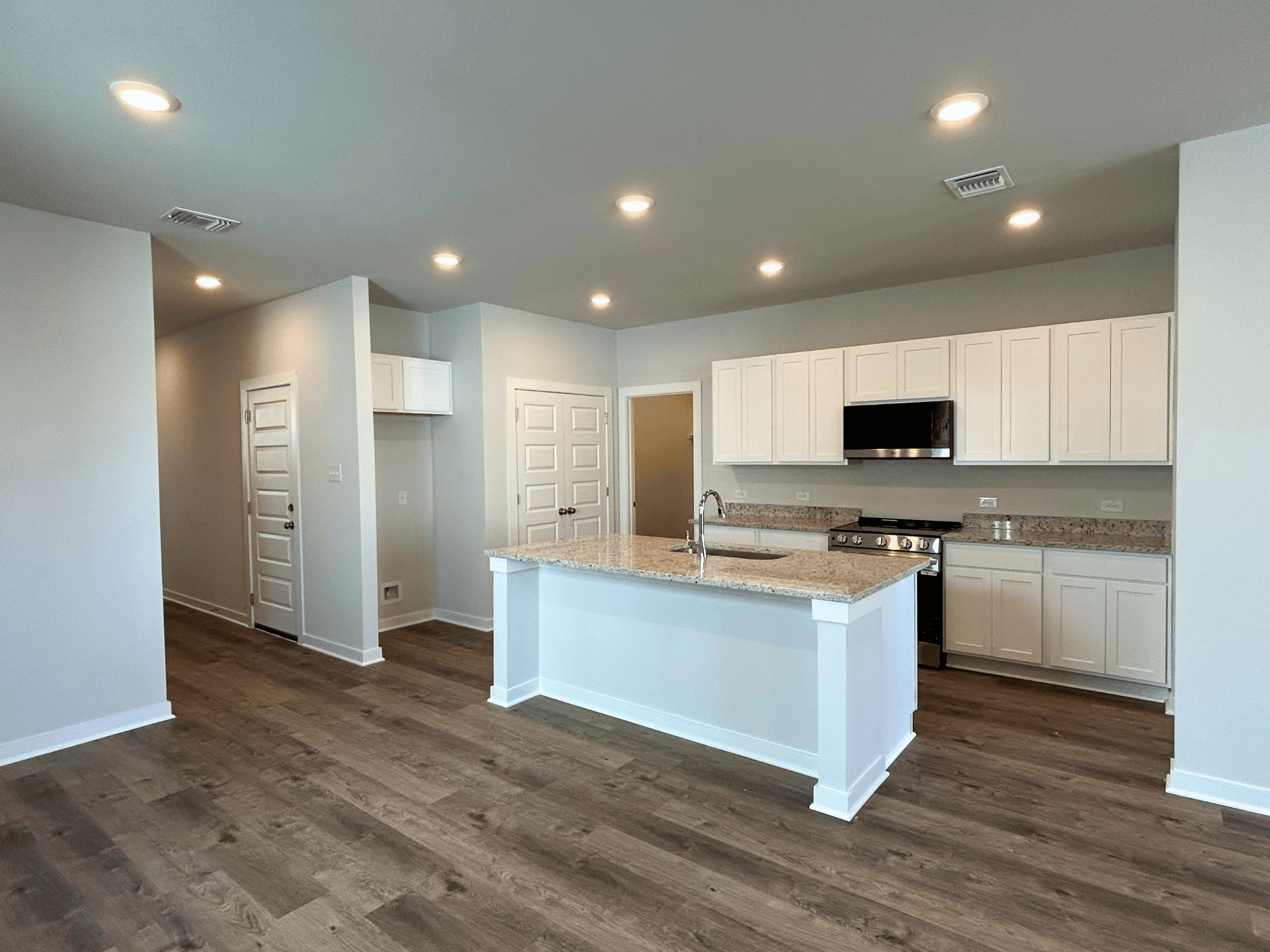 A kitchen with white cabinets.