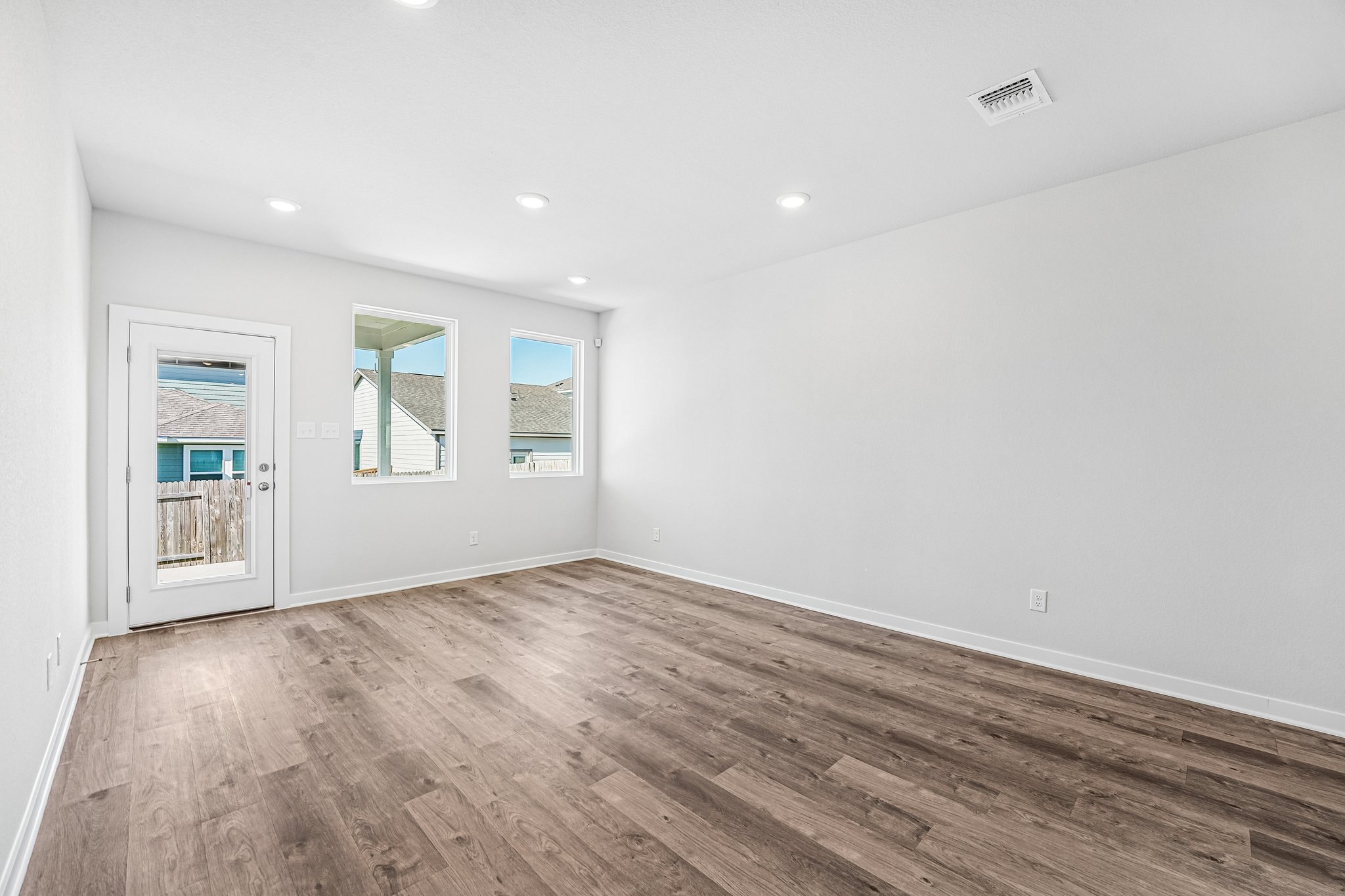A room with white walls and wood floors.