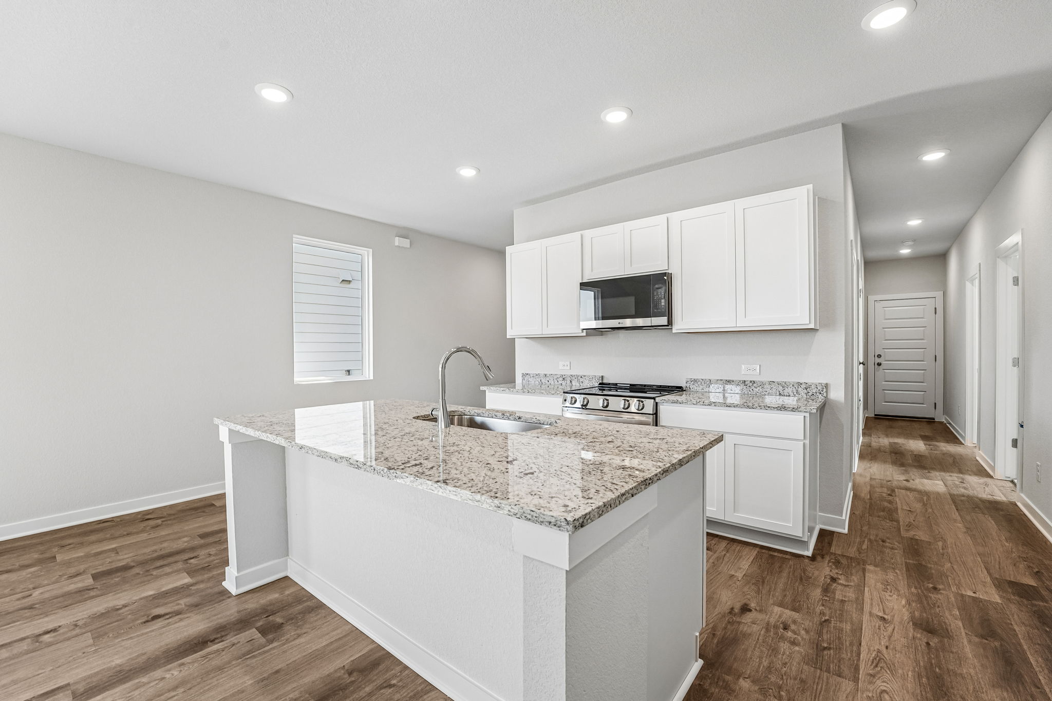 A kitchen with white cabinets.