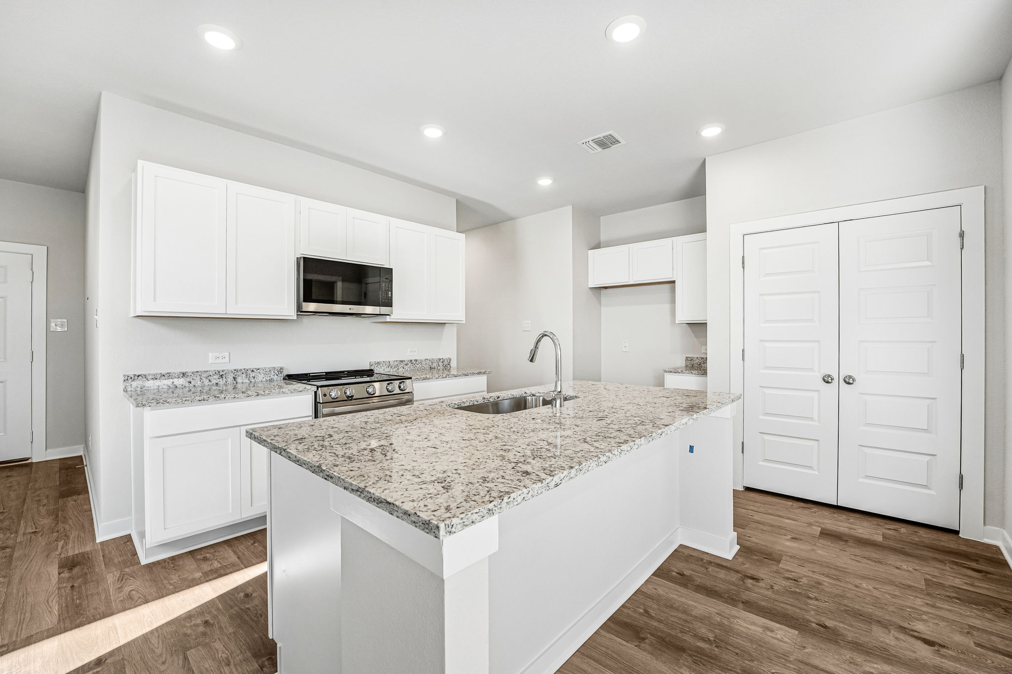 A kitchen with white cabinets.