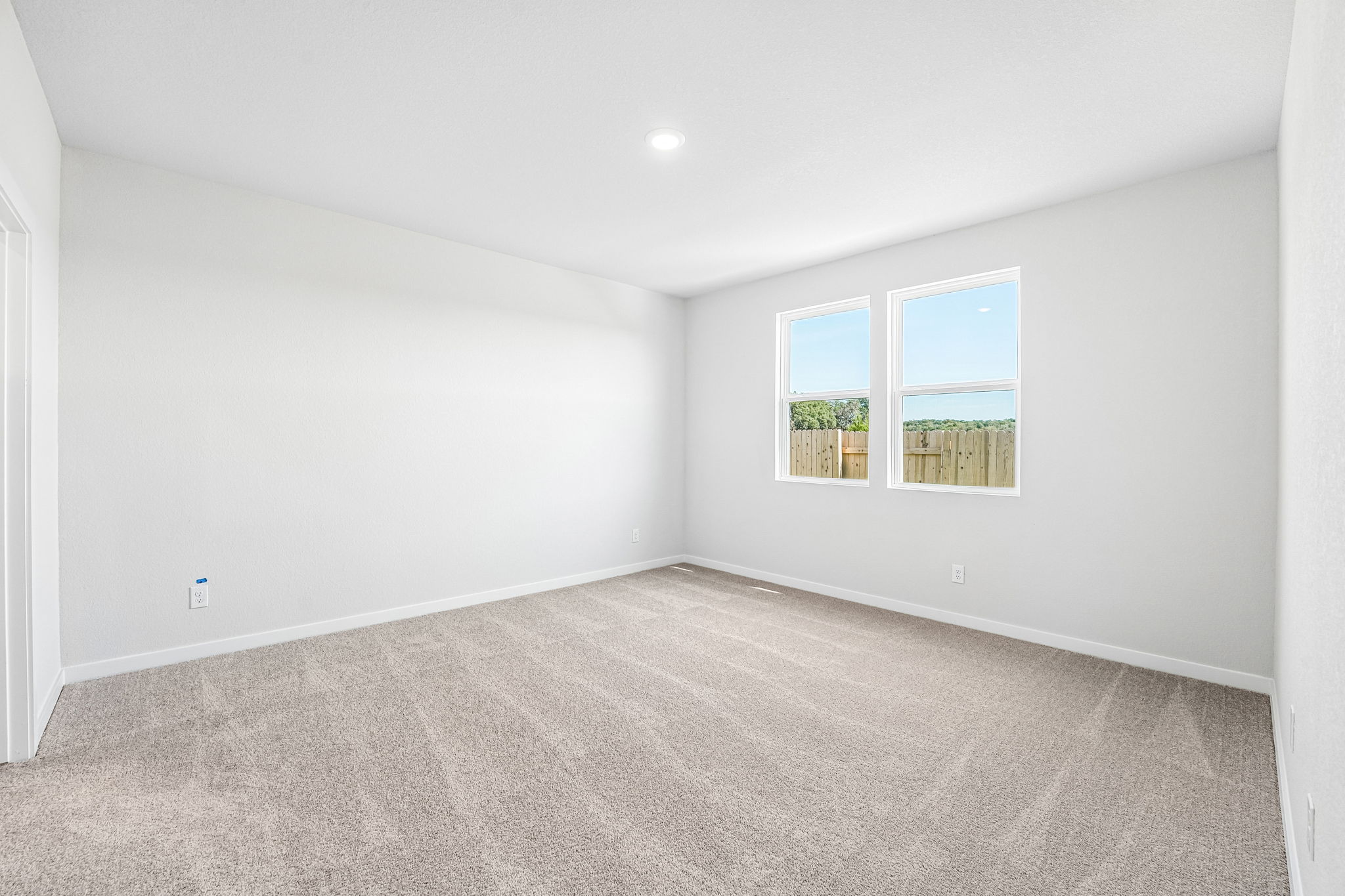 A room with a carpet and windows.