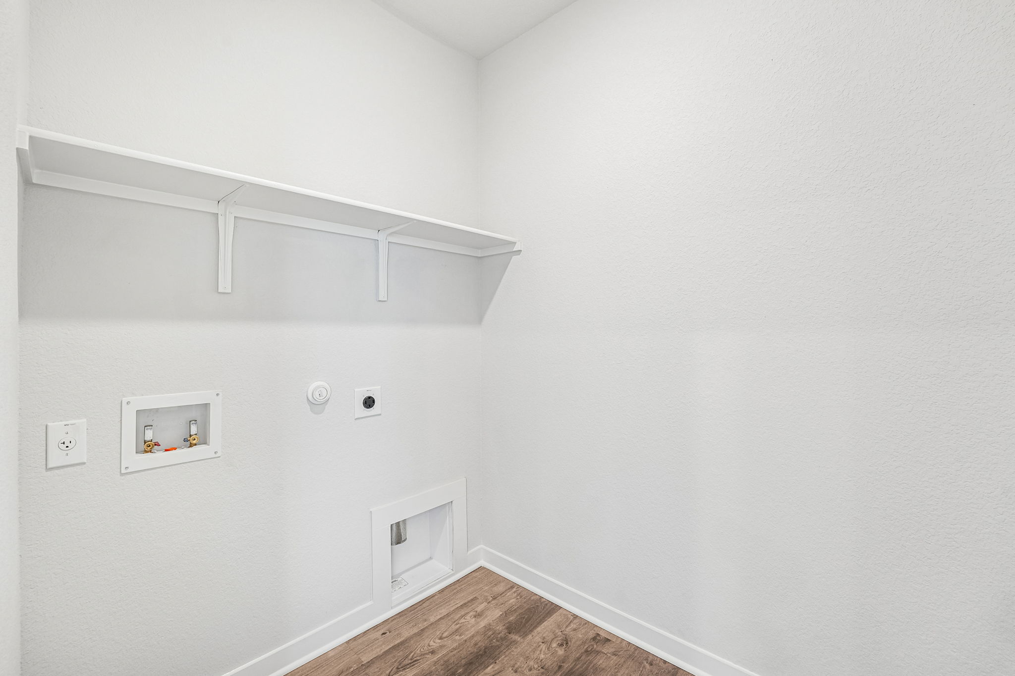 A white wall with a white shelf.