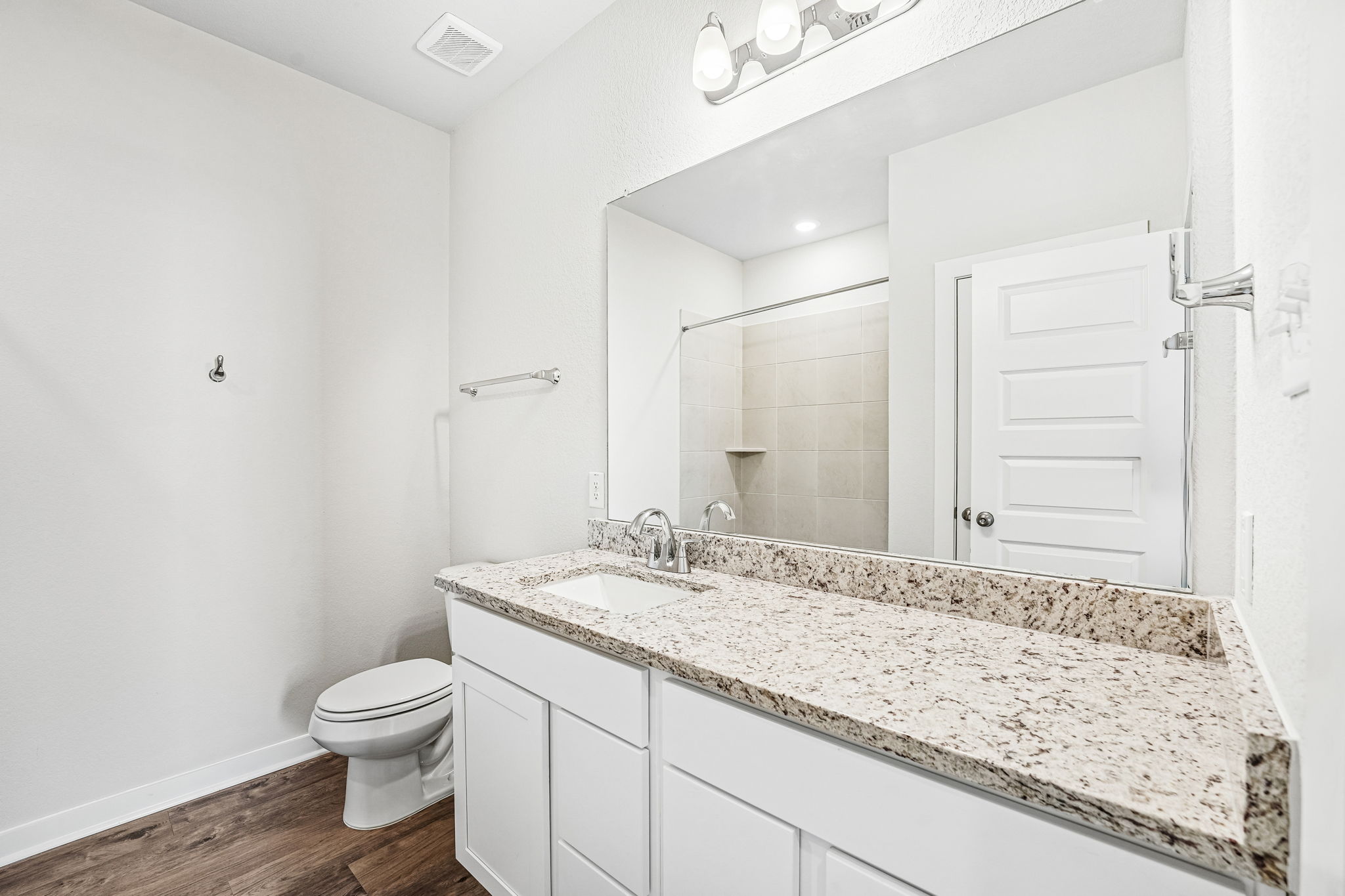 A bathroom with a large mirror.