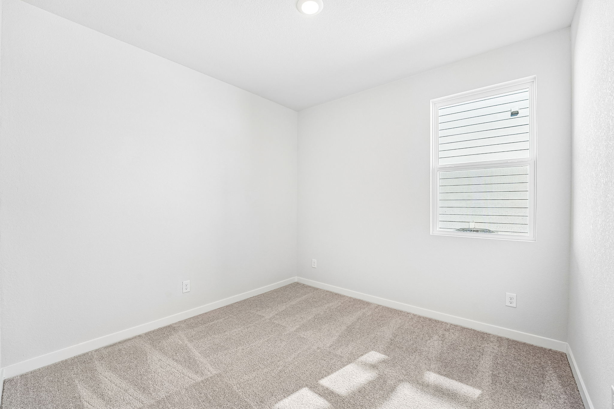 A room with a tile floor and a white wall with a vent.
