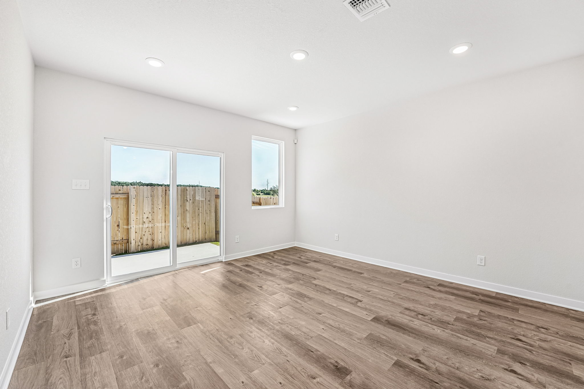 A room with a wood floor and a wood floor with a door.