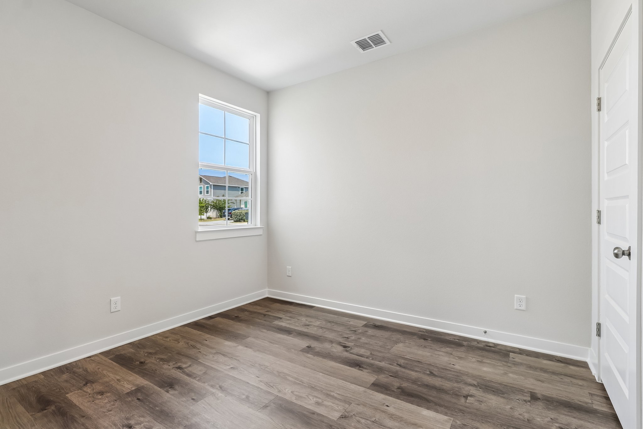 A room with a wood floor and a window.