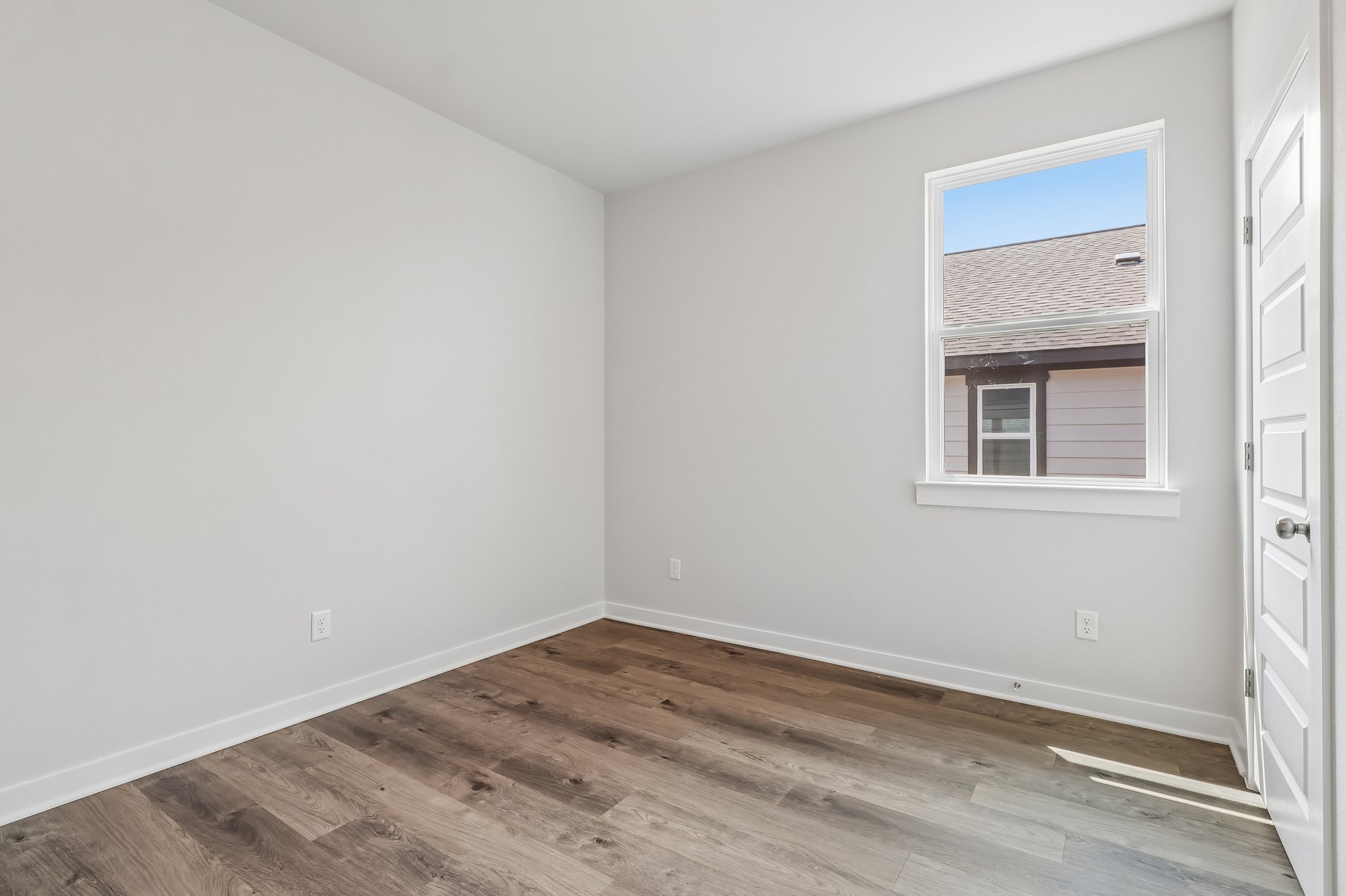A room with a wood floor and a window.