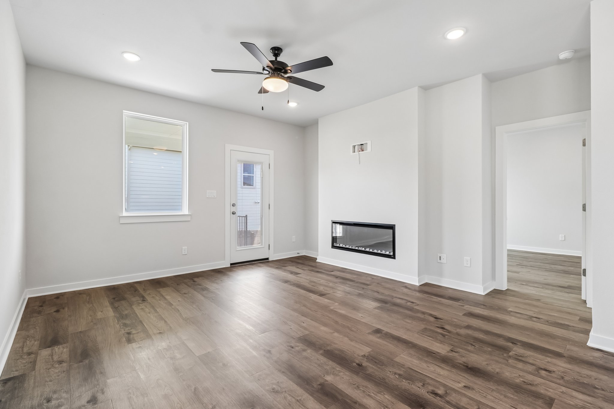 A room with a wood floor and a ceiling fan.