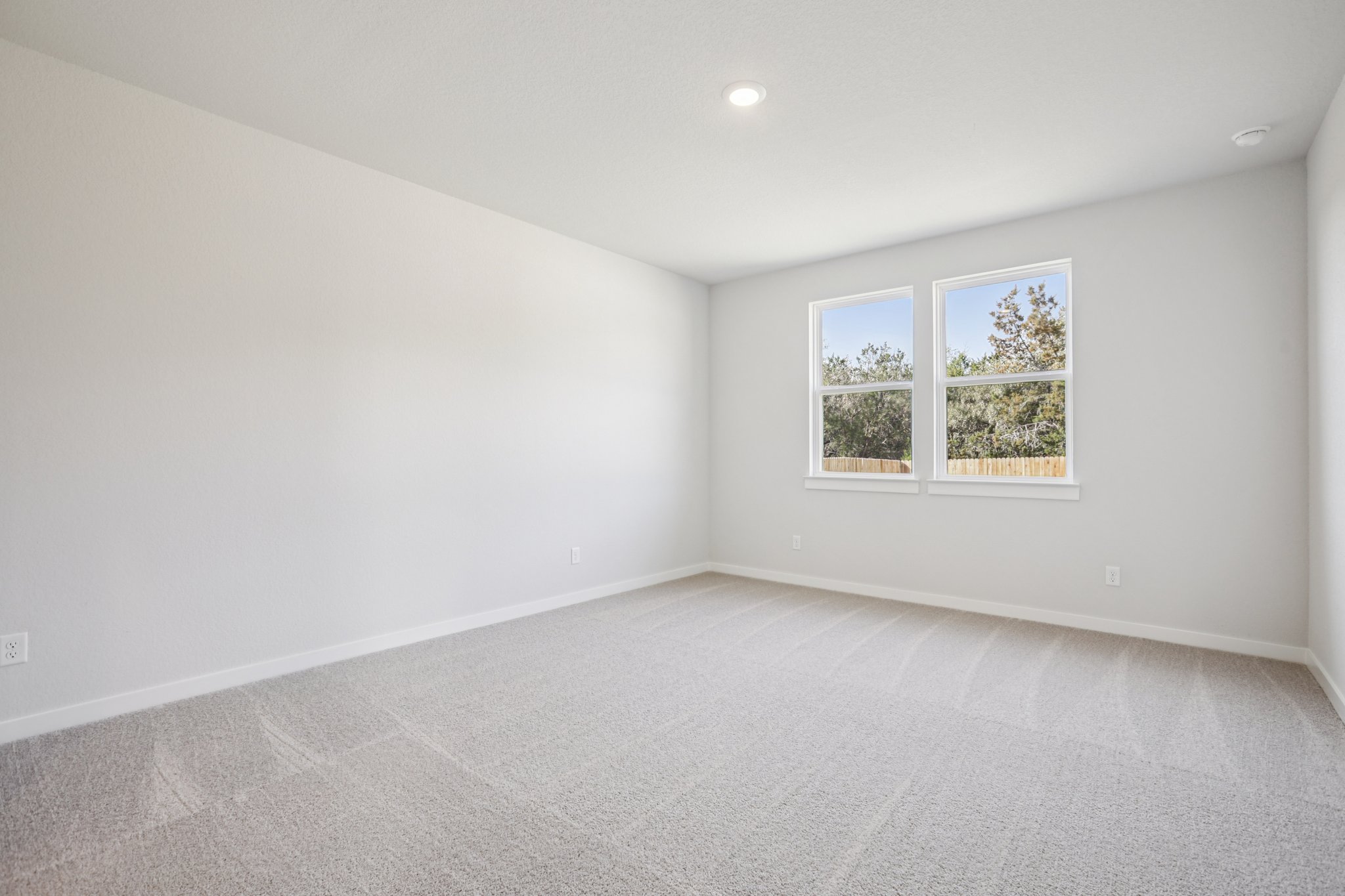 A room with a window and a white wall.