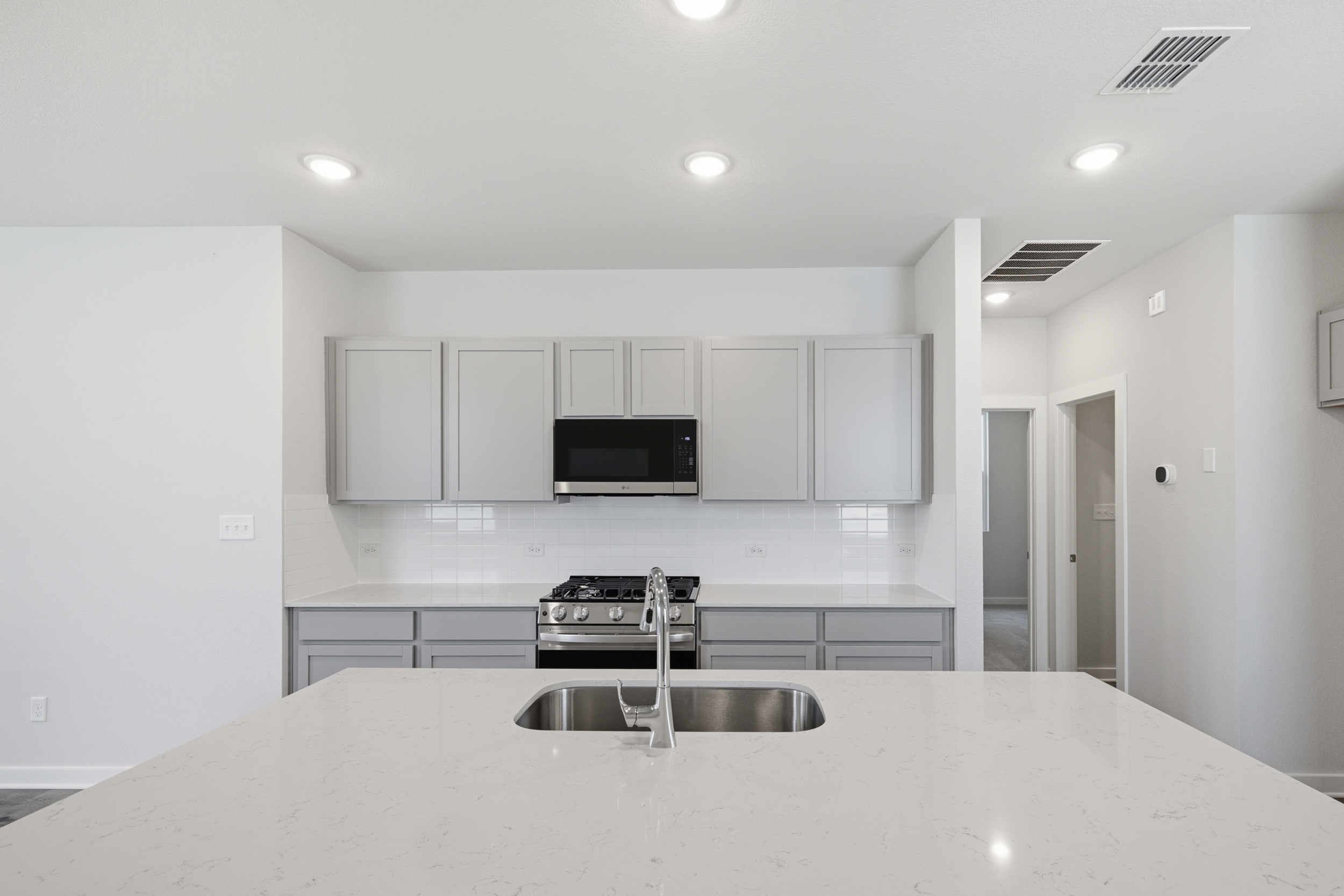 A kitchen with white cabinets.