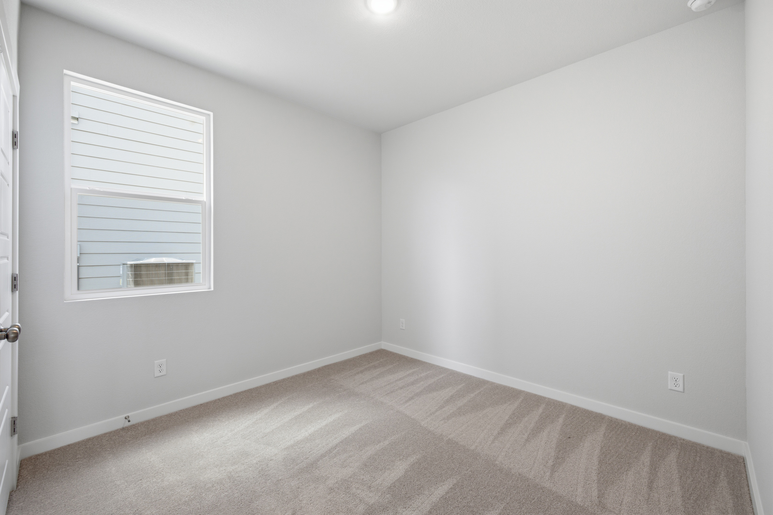 A room with a carpet and a window.
