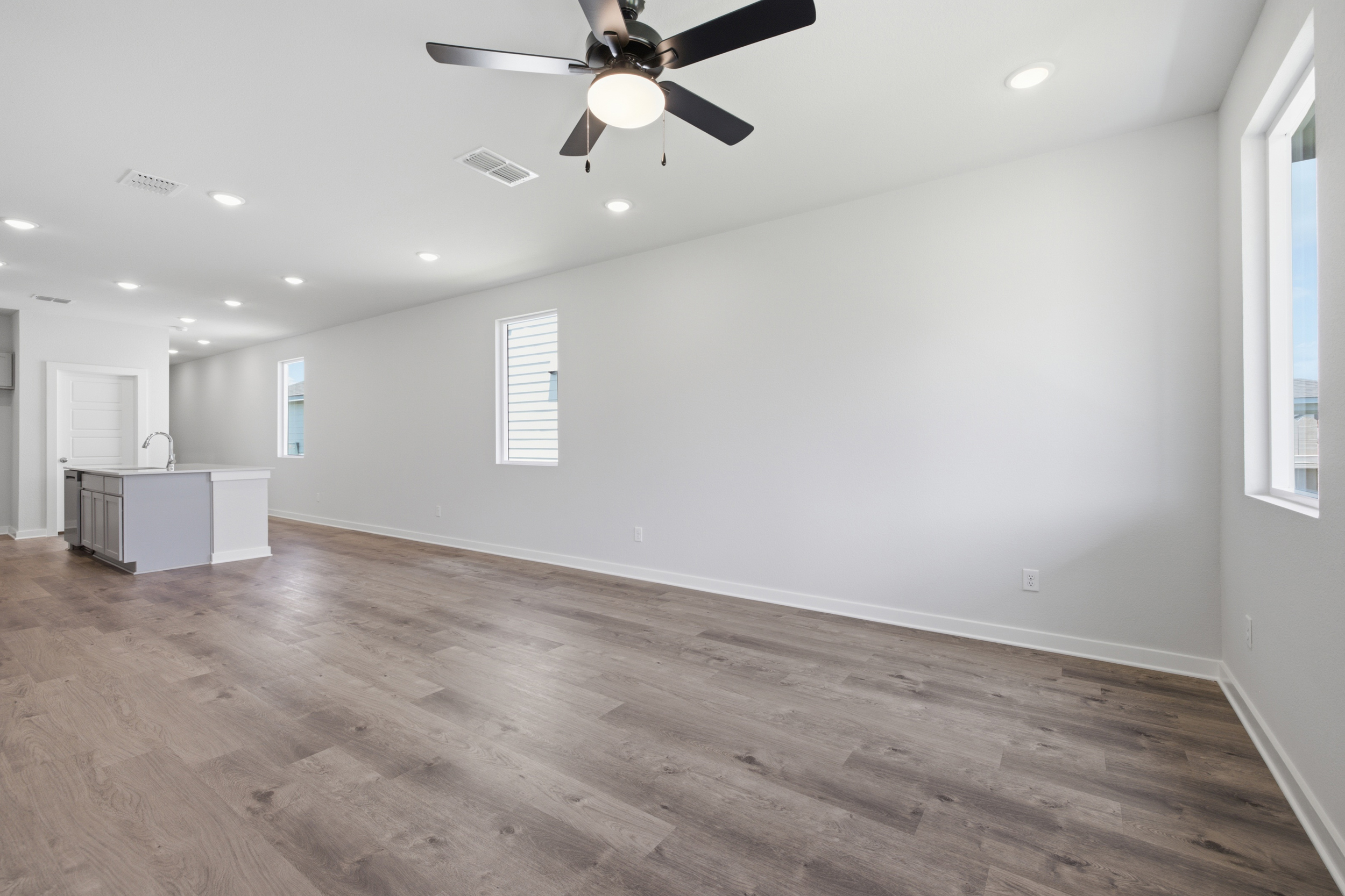 A room with a wood floor and a ceiling fan.