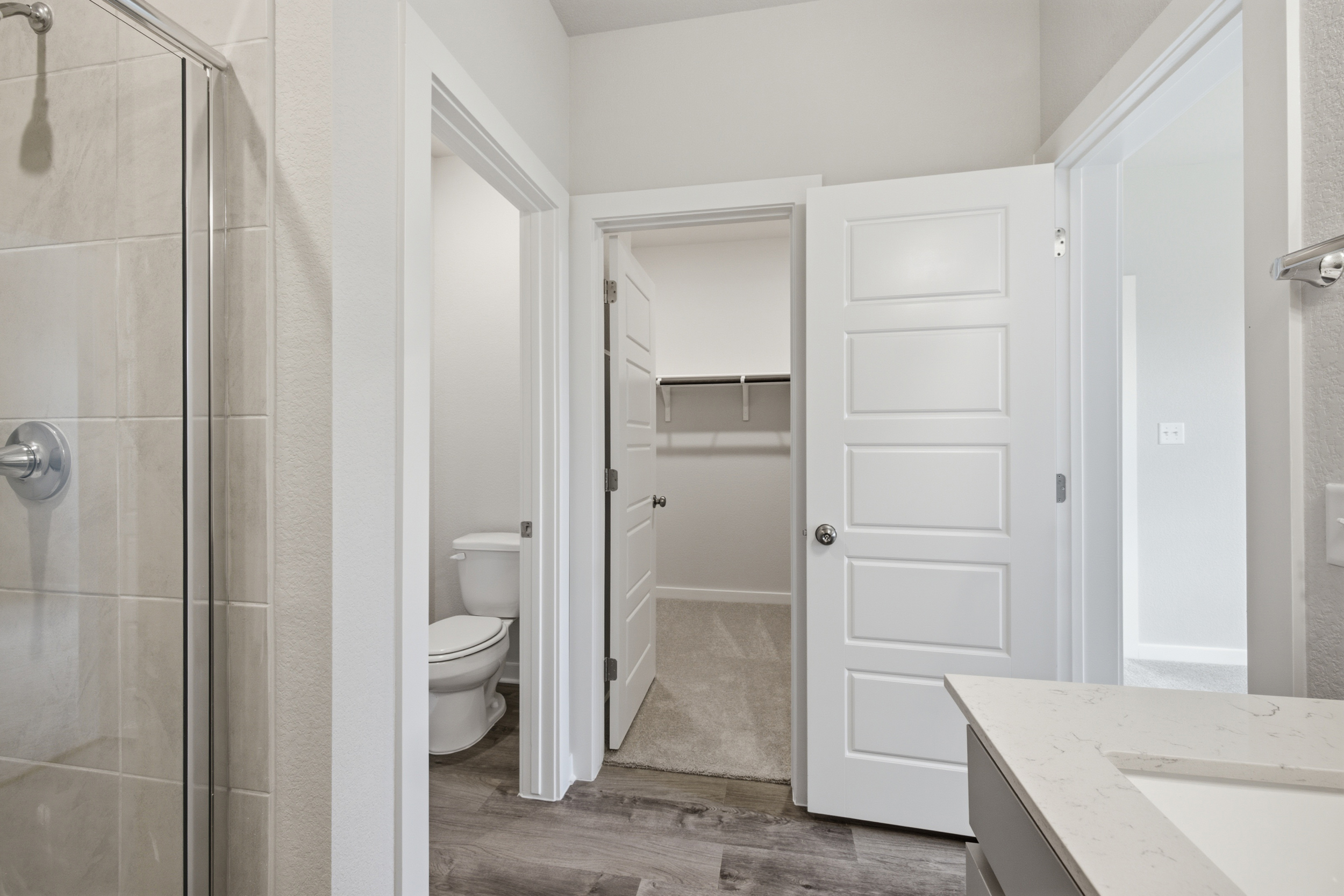 A bathroom with a shower unit and toilet.