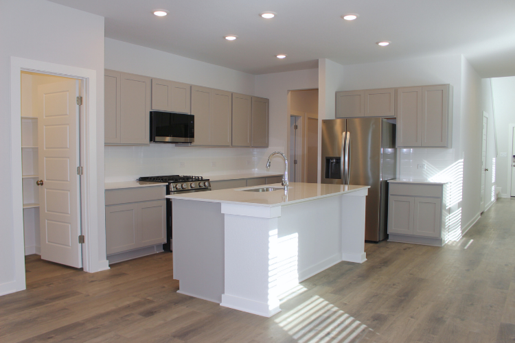 A kitchen with white cabinets.