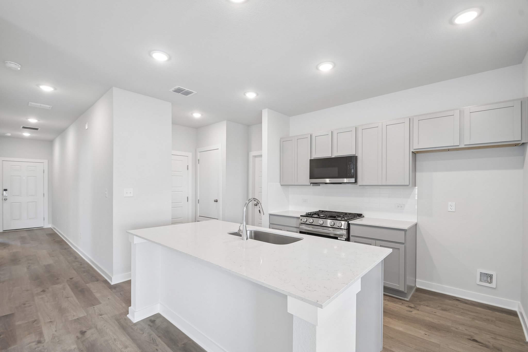 A kitchen with white cabinets.