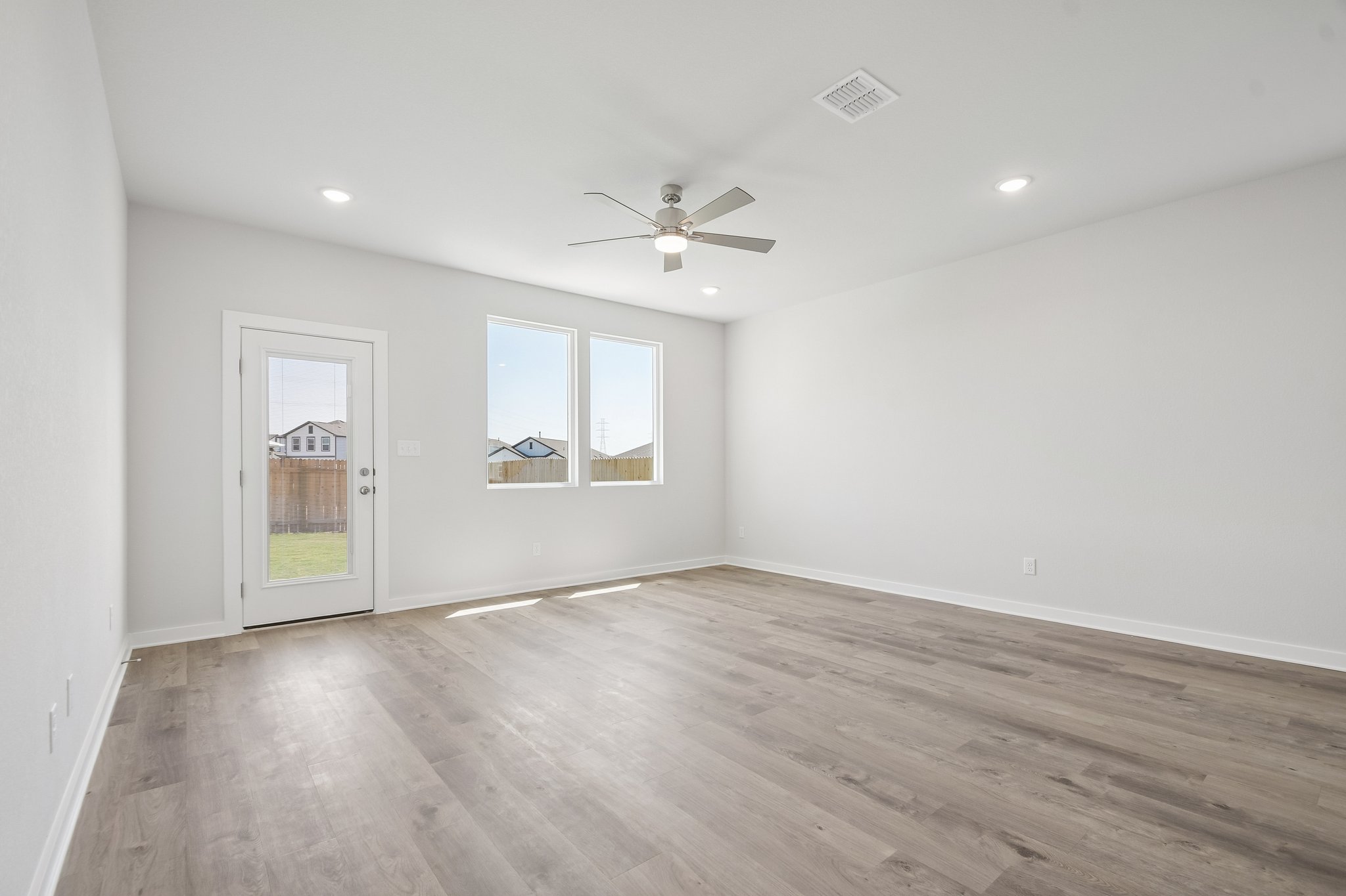A room with a wood floor and a ceiling fan.
