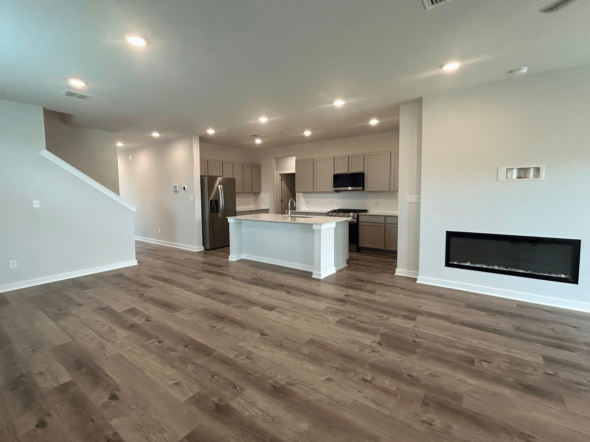 A large kitchen with a wood floor.