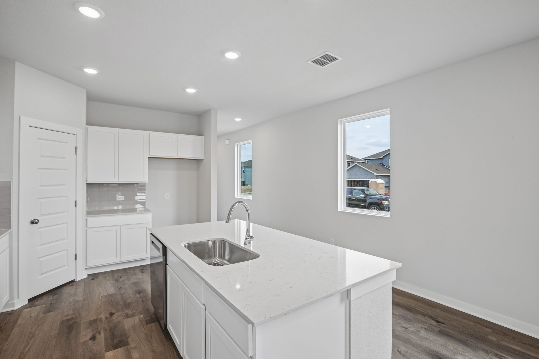A kitchen with white cabinets.