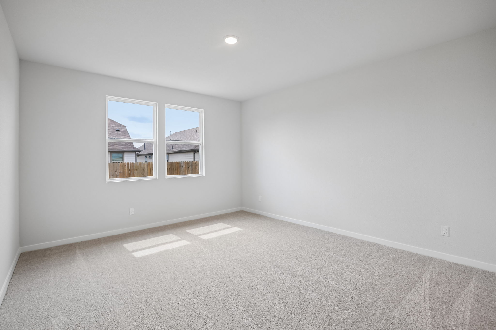 A room with a window and a white wall.