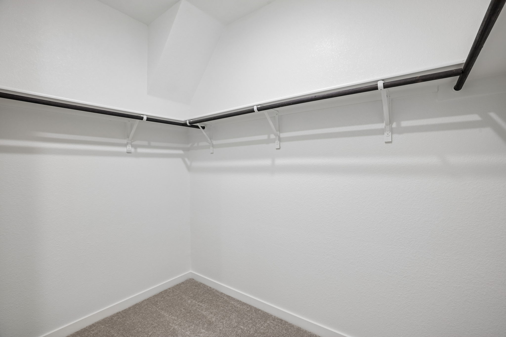 A white wall with a metal bar.