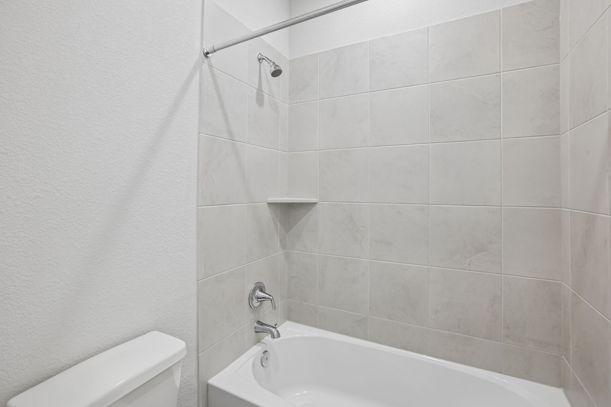 A bathtub and a shower unit in a bathroom.
