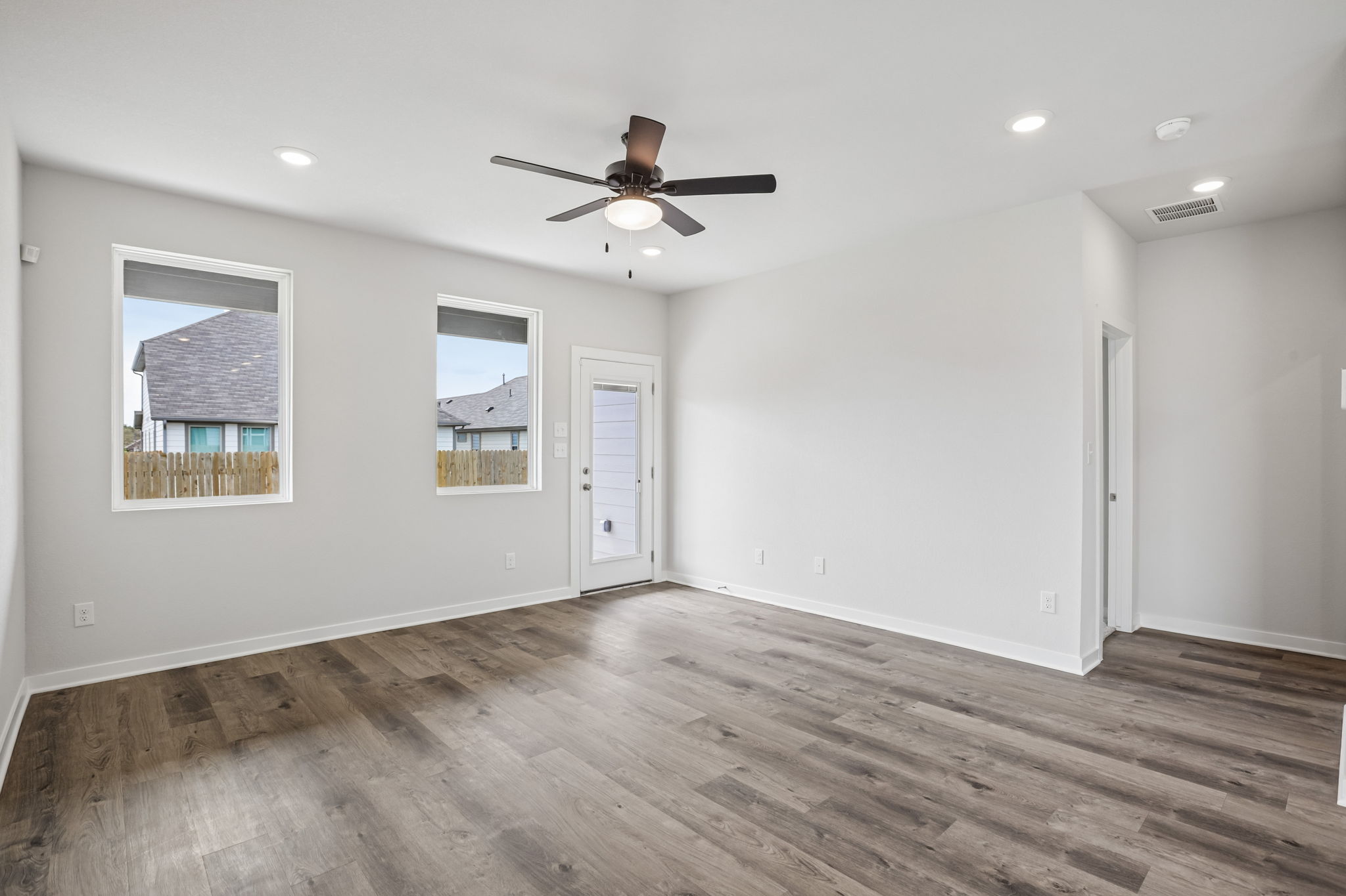 A room with a wood floor and a ceiling fan.