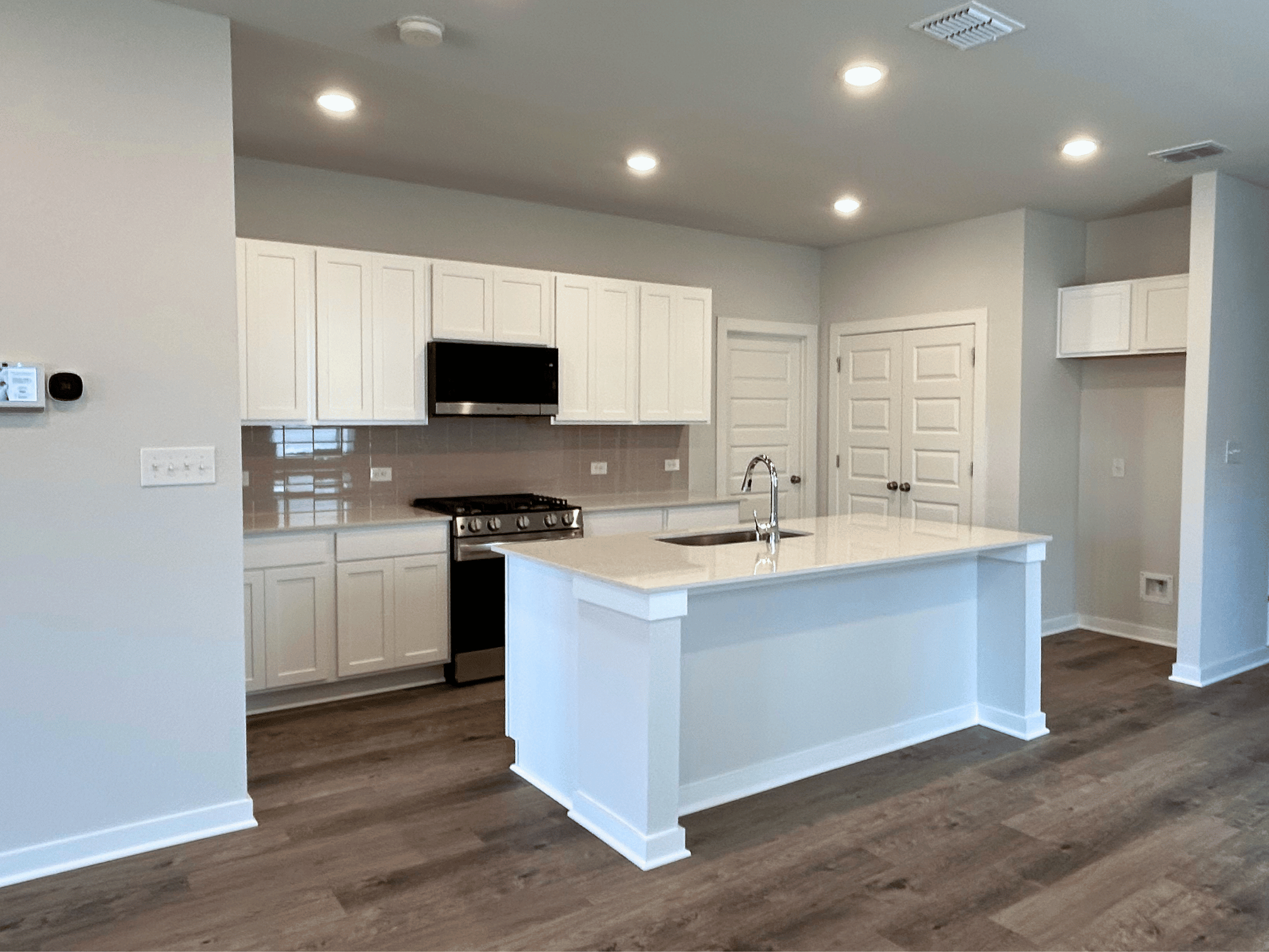 A kitchen with white cabinets.