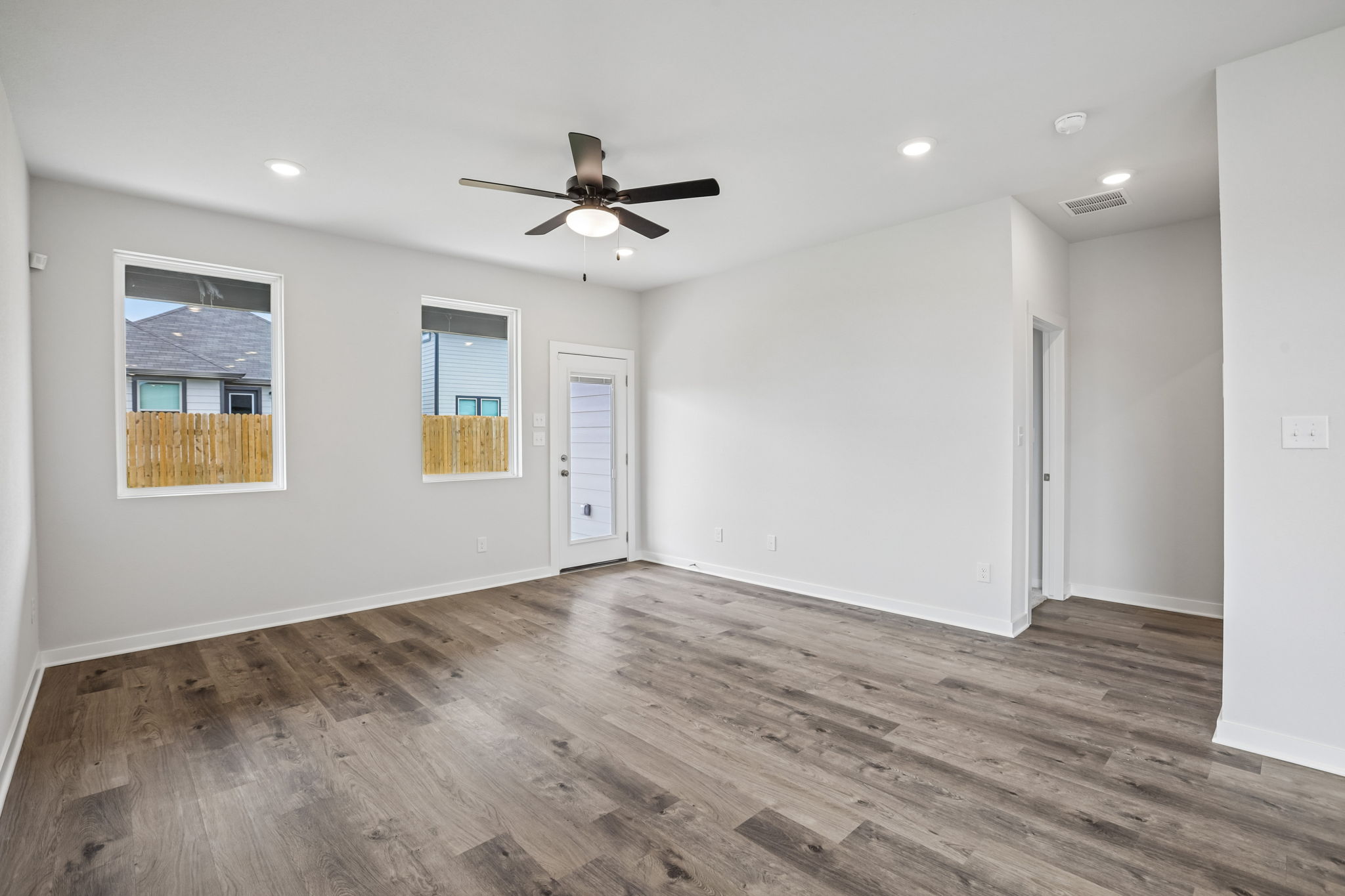 A room with a wood floor and a ceiling fan.