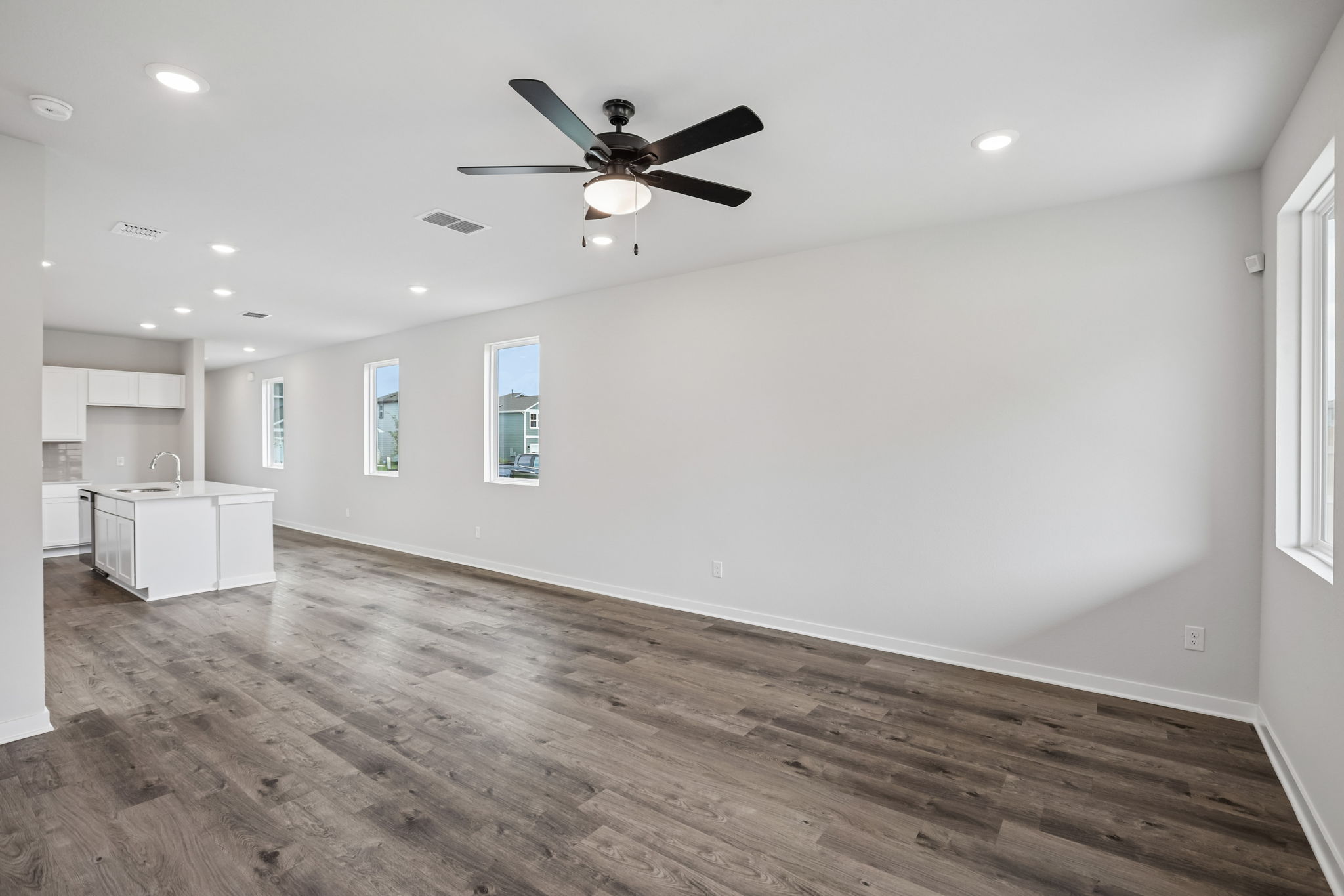 A room with a wood floor and a ceiling fan.