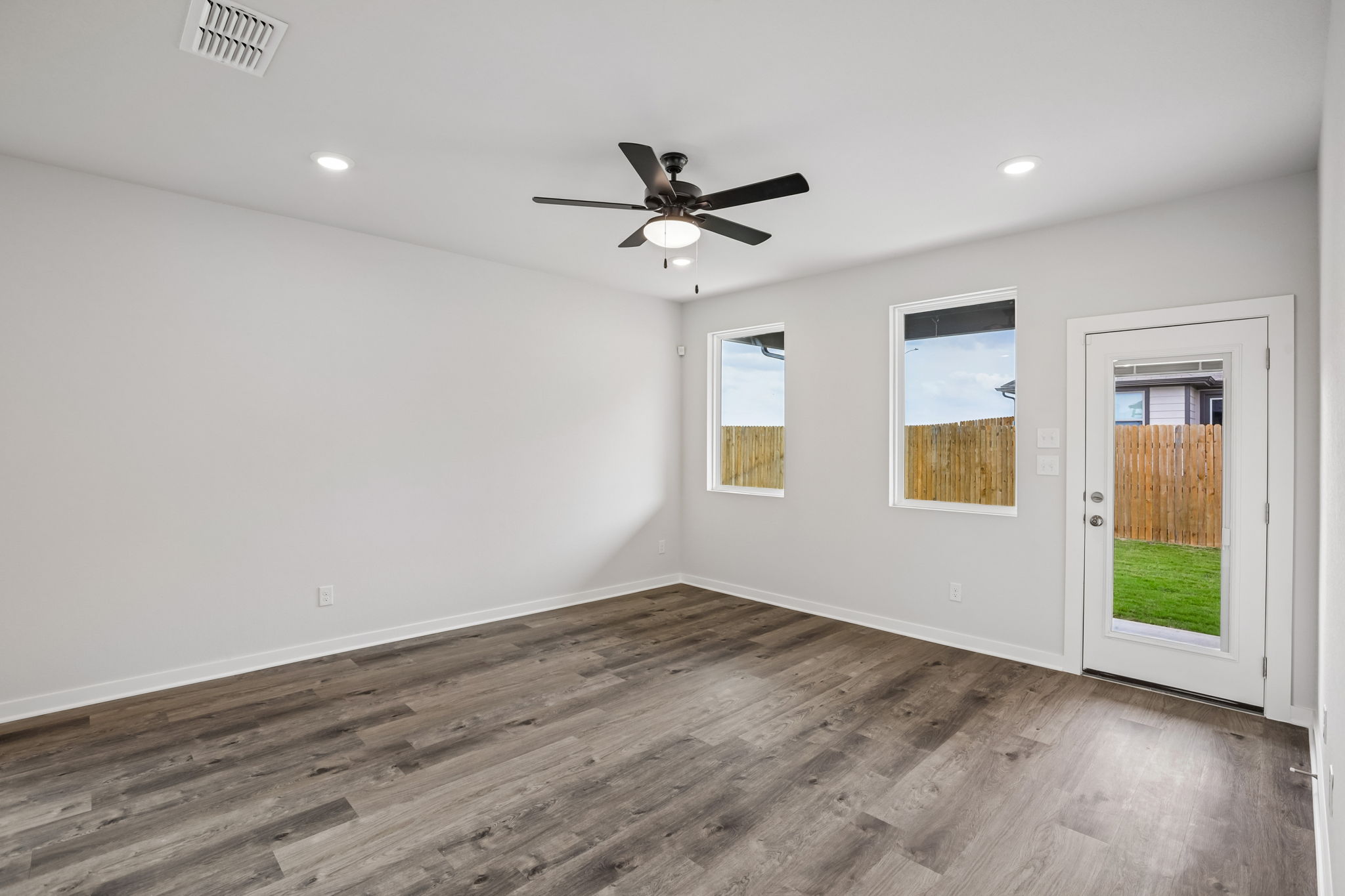 A room with a wood floor and a ceiling fan.