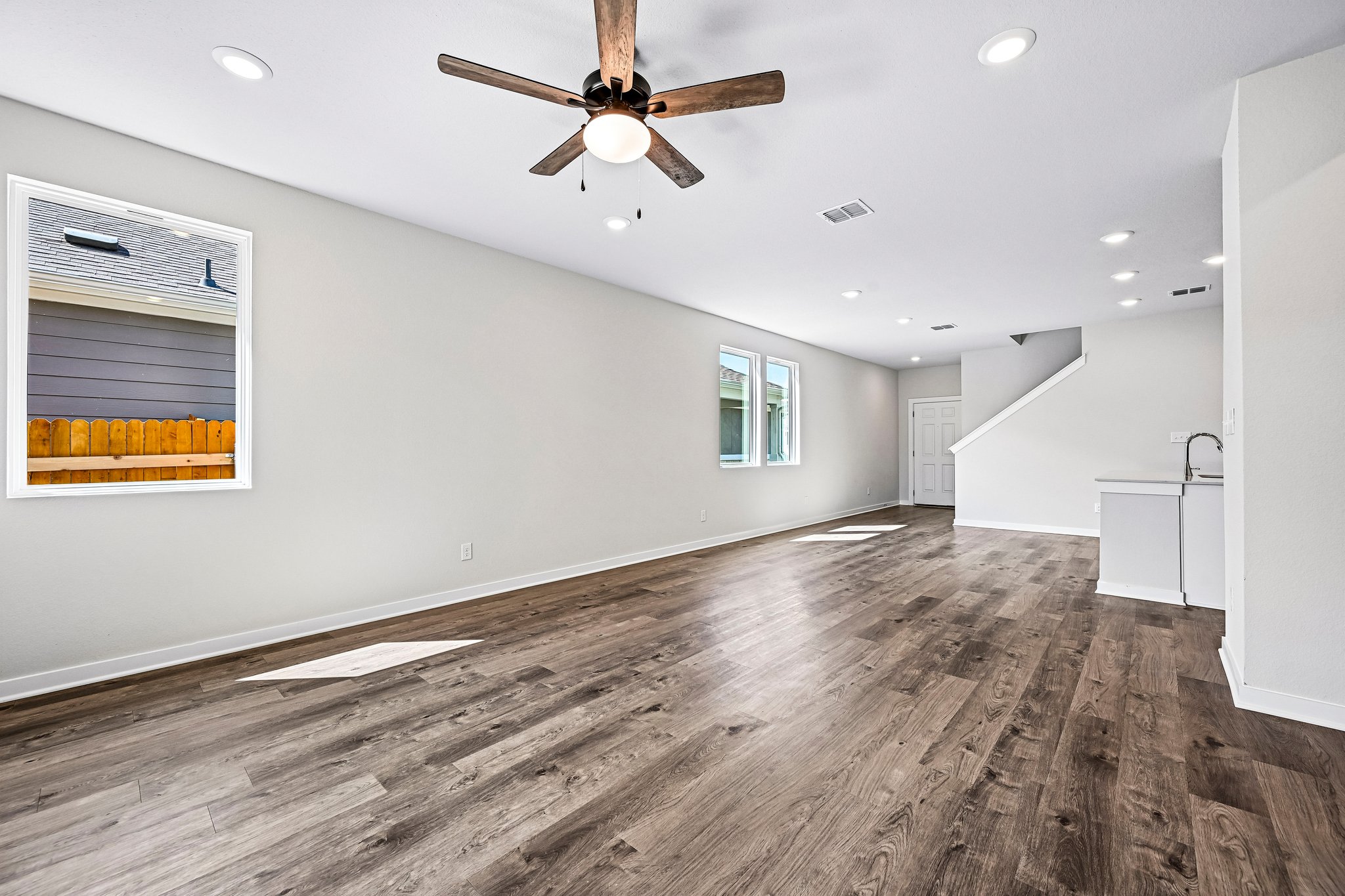 A room with a wood floor and a ceiling fan.
