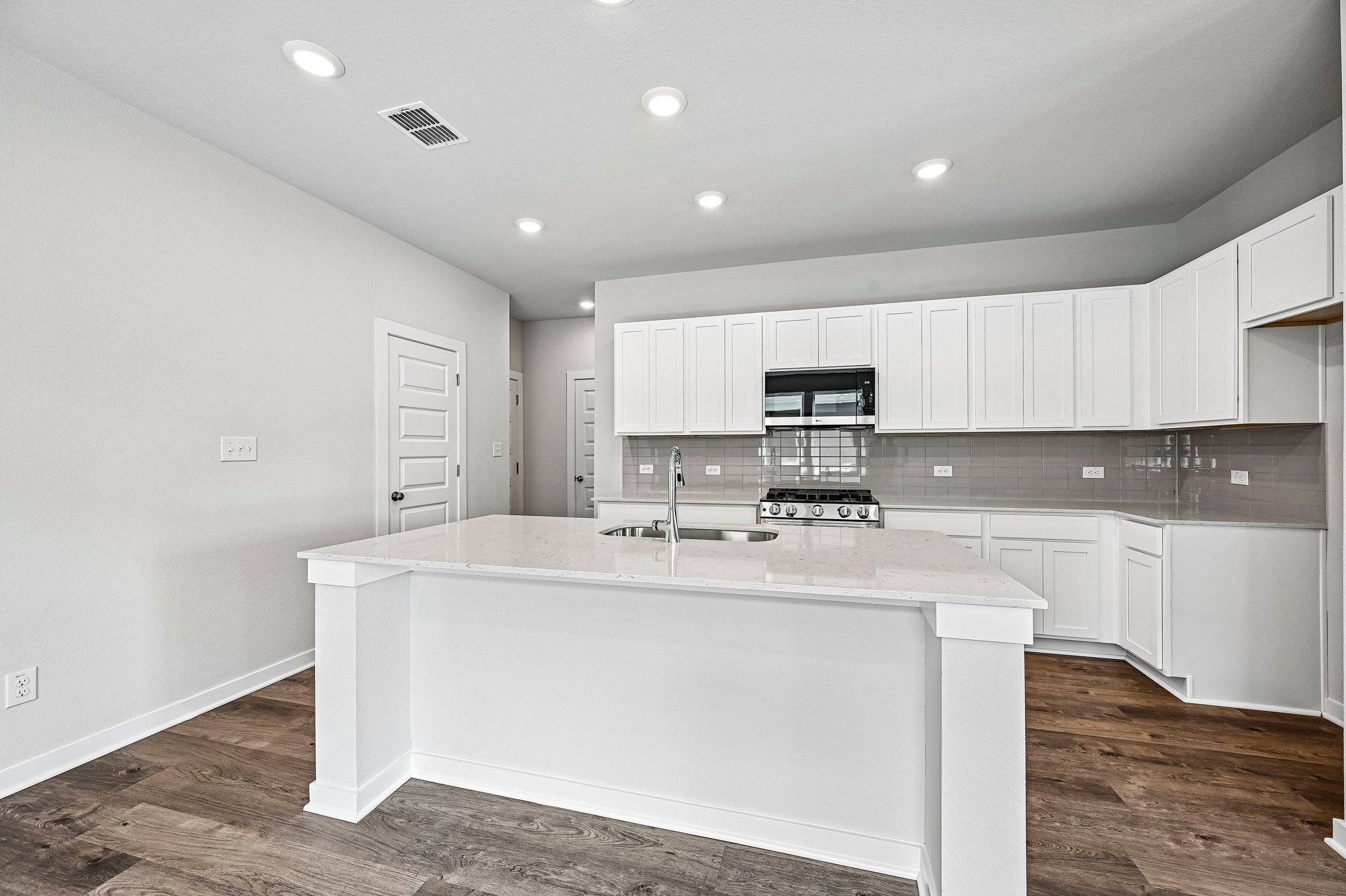 A kitchen with white cabinets.