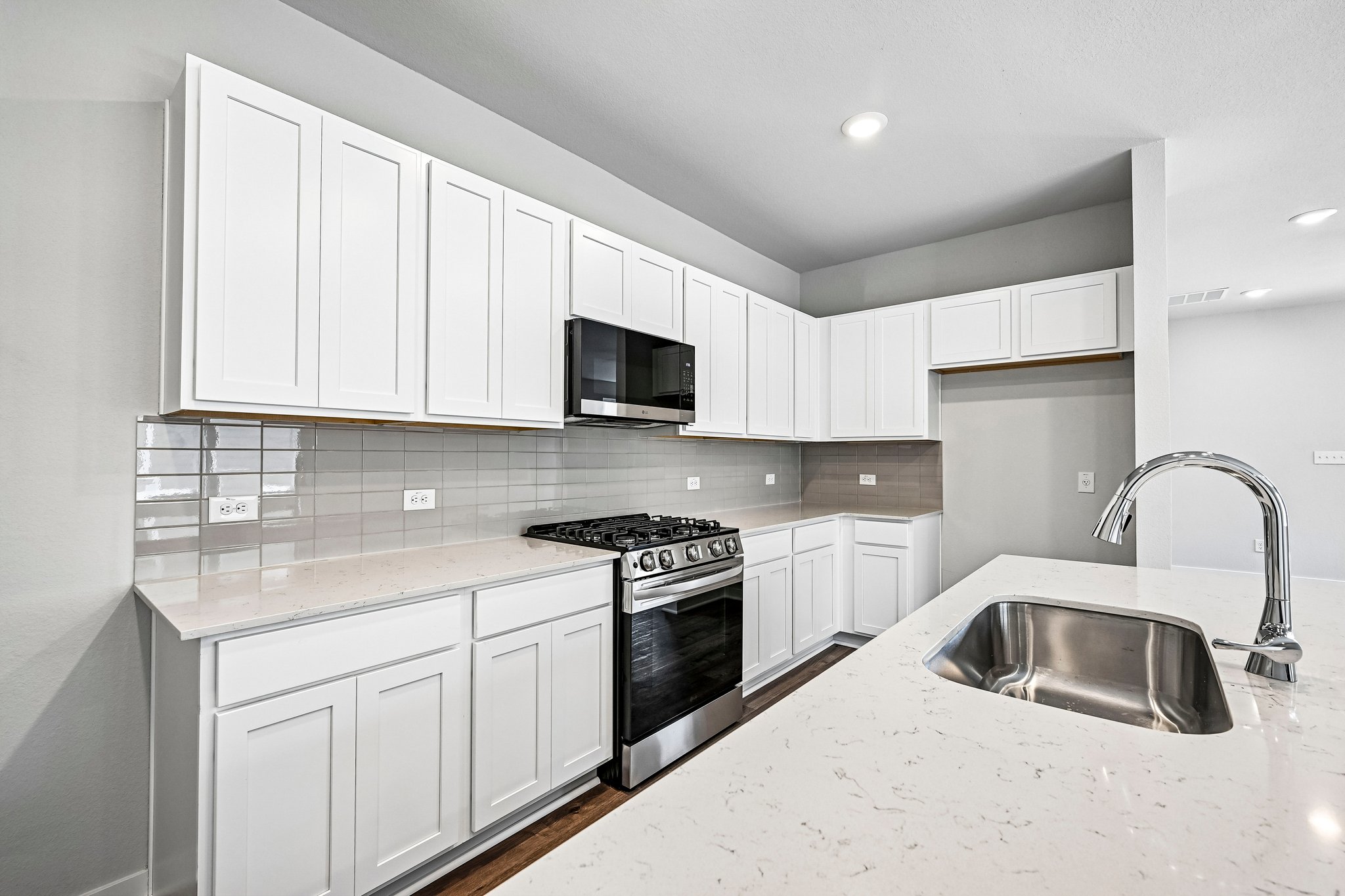 A kitchen with white cabinets.