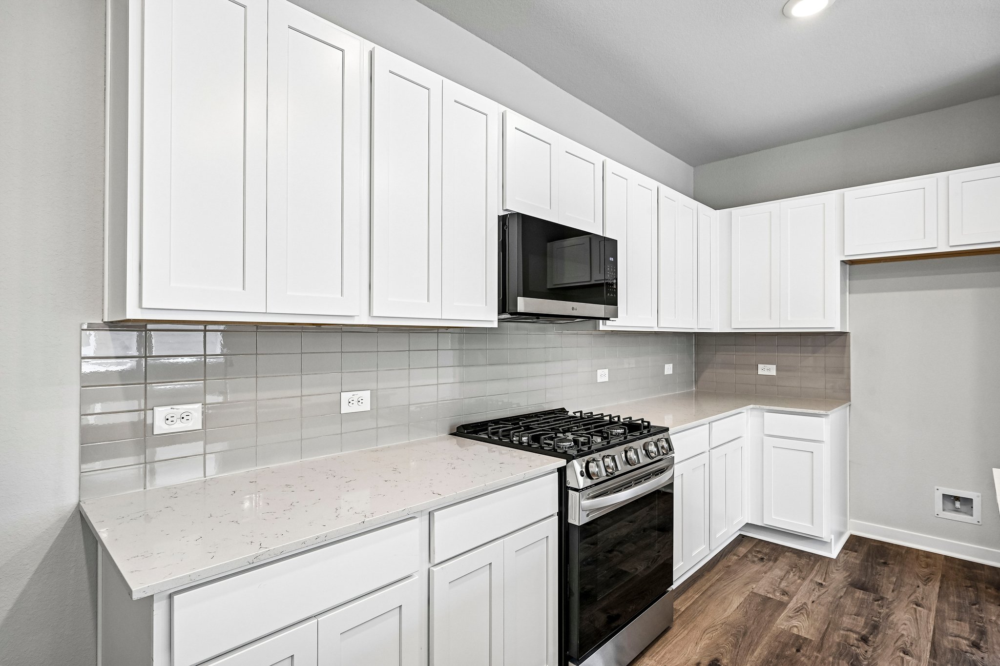 A kitchen with white cabinets.
