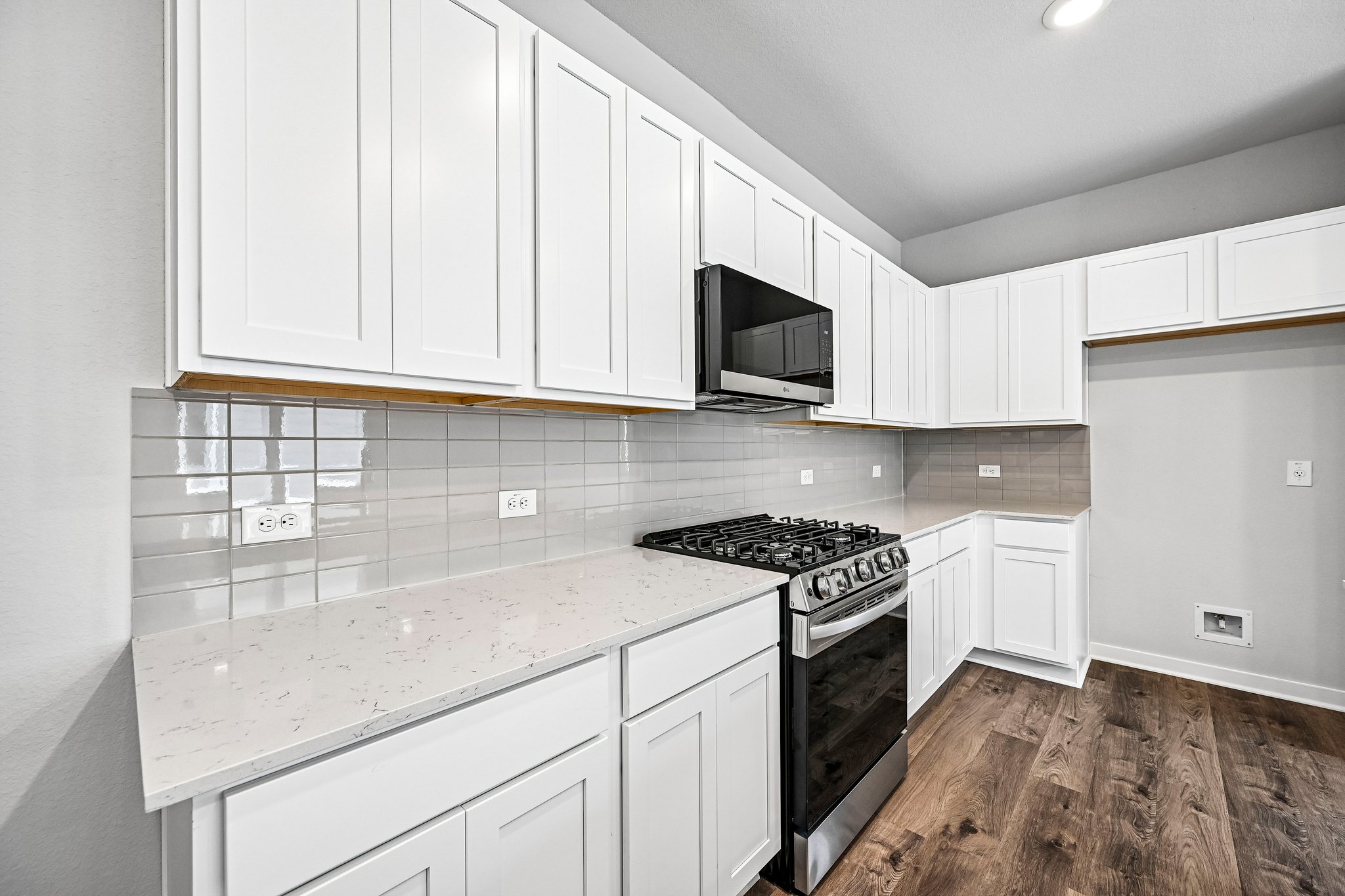 A kitchen with white cabinets.
