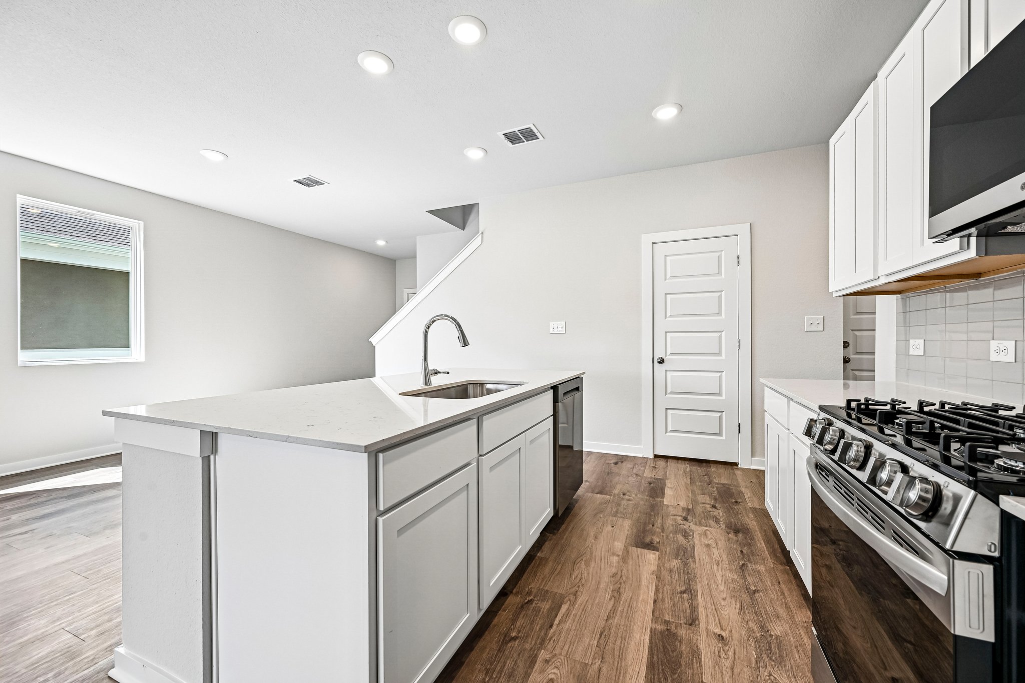 A kitchen with white cabinets.