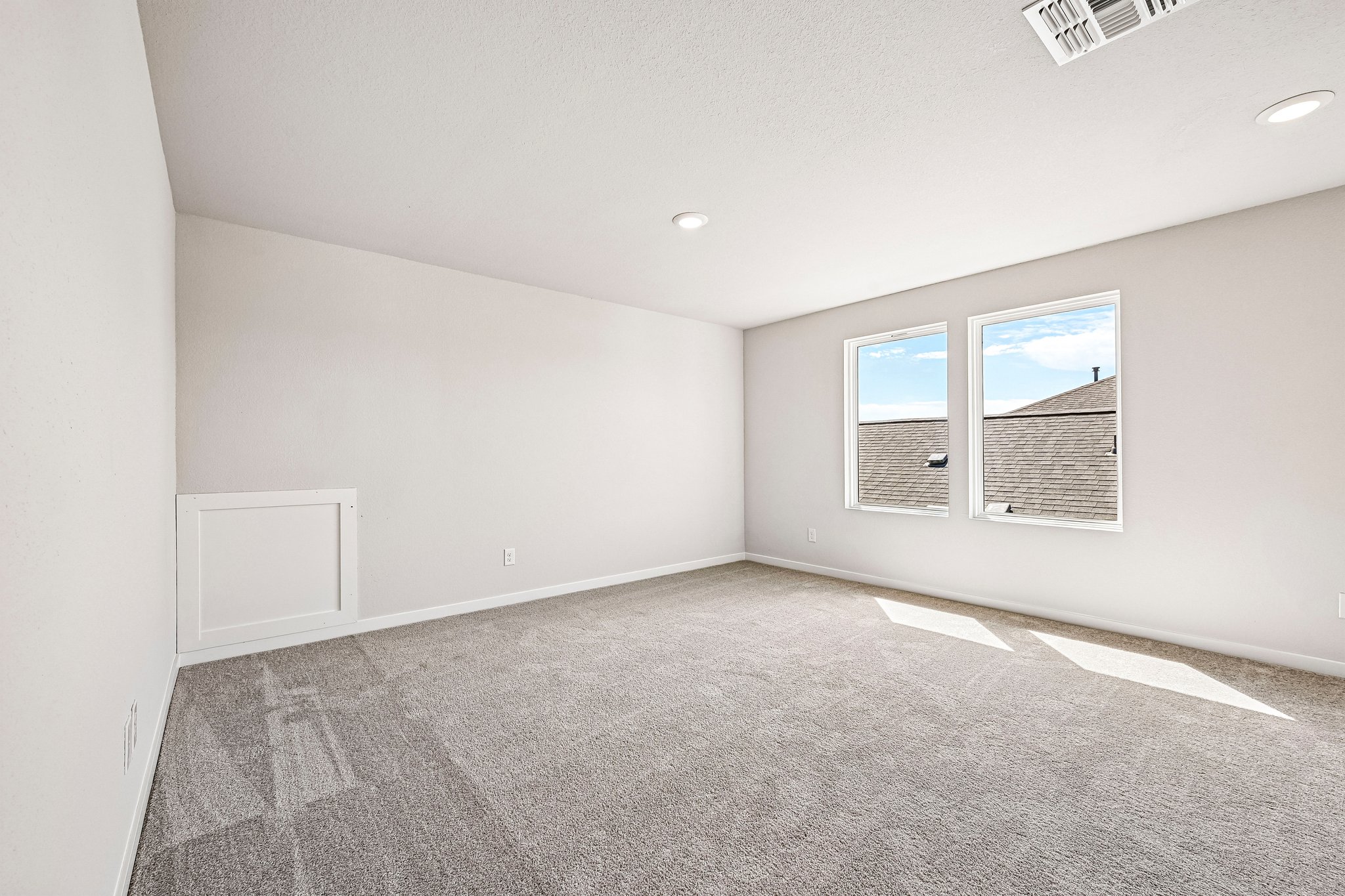 A room with a window and a carpet.