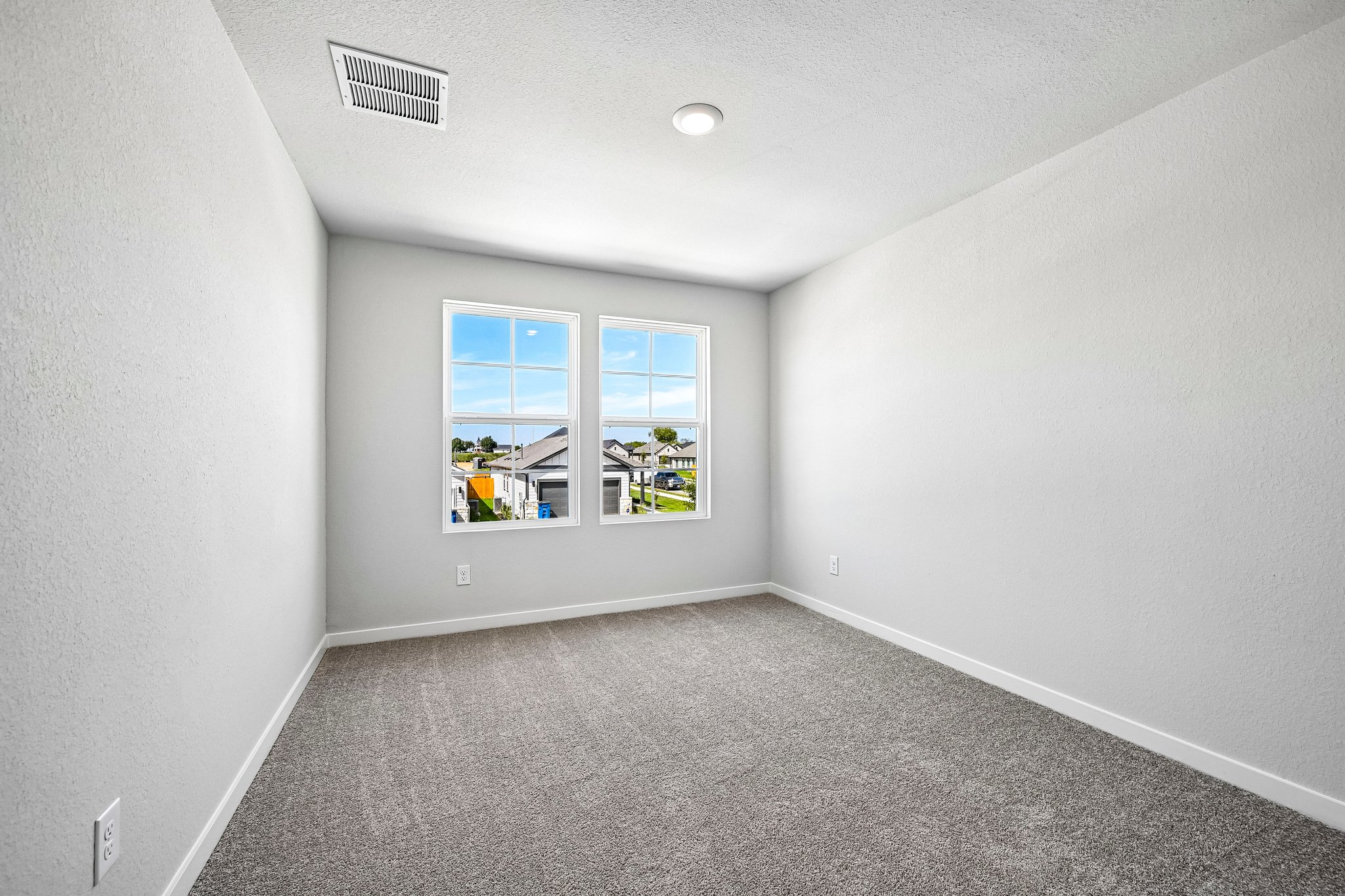 A room with a window and a carpet.