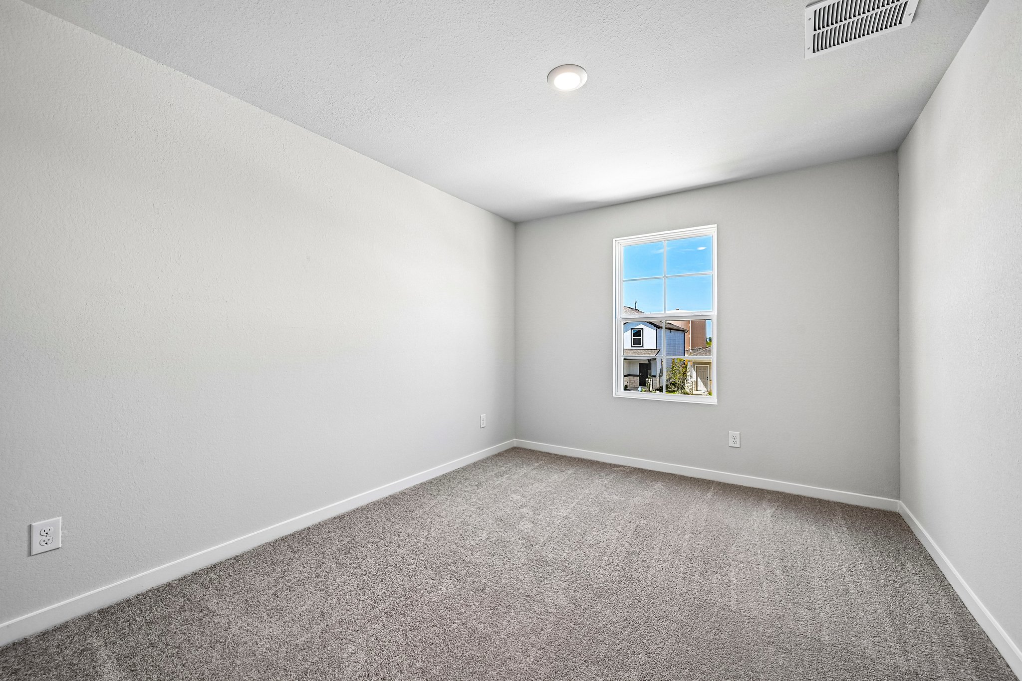 A room with a window and a carpet.