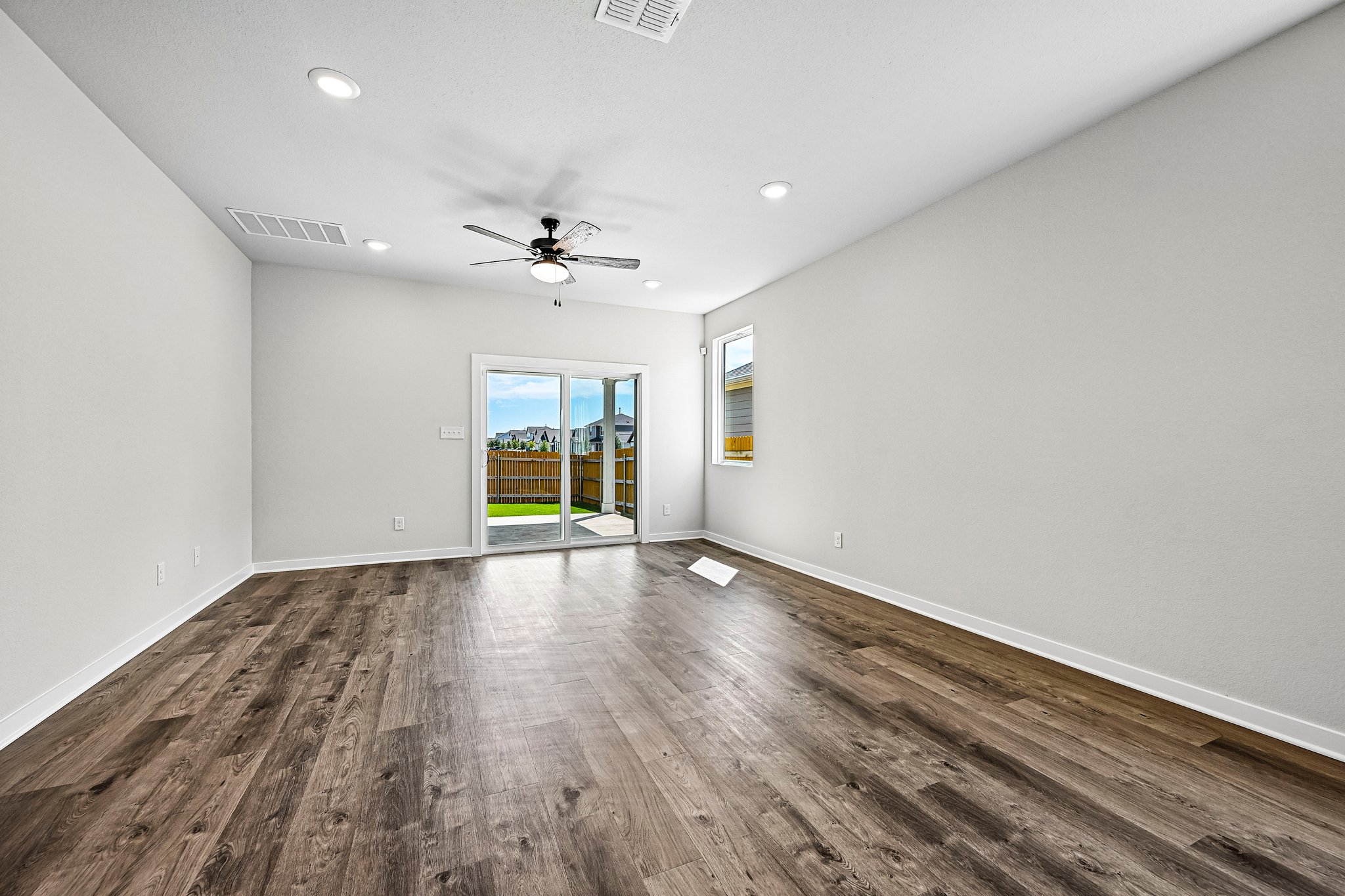 A room with a wood floor and a ceiling fan.