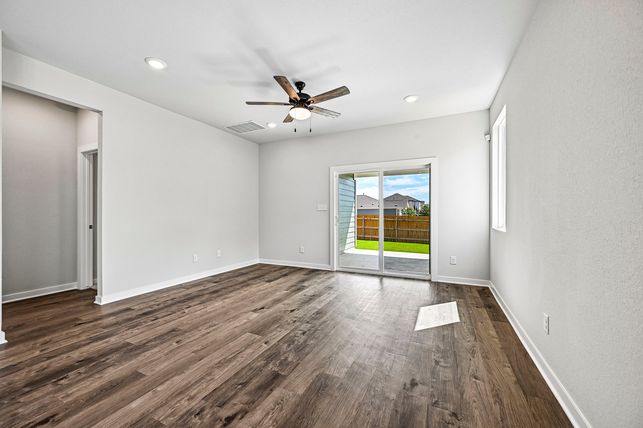 A room with a wood floor and a ceiling fan.