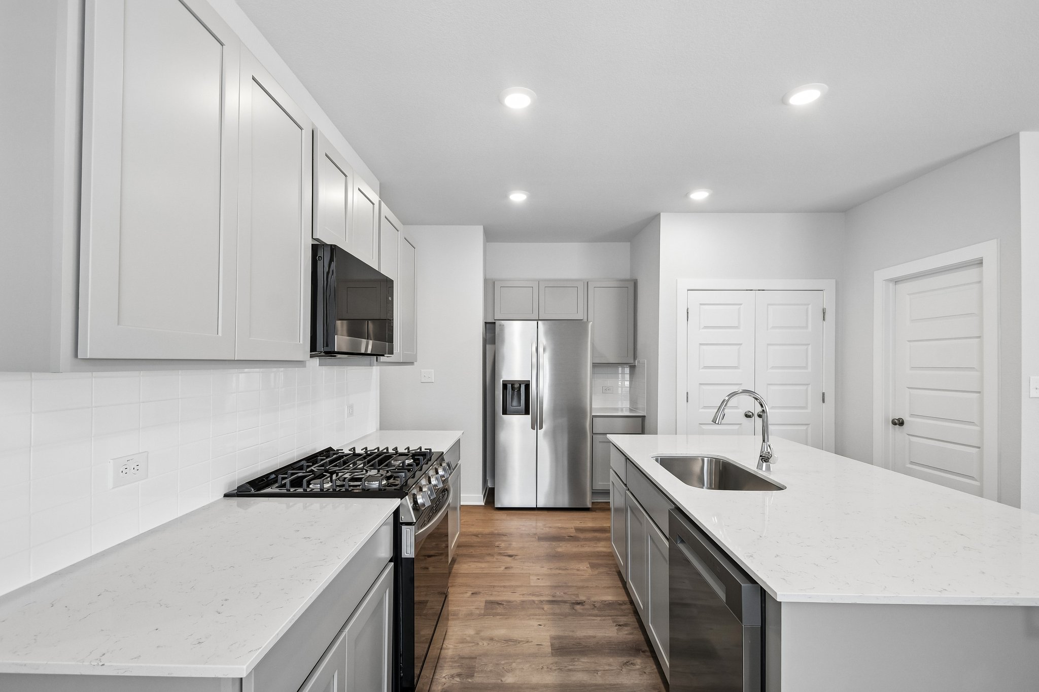 A kitchen with white cabinets.