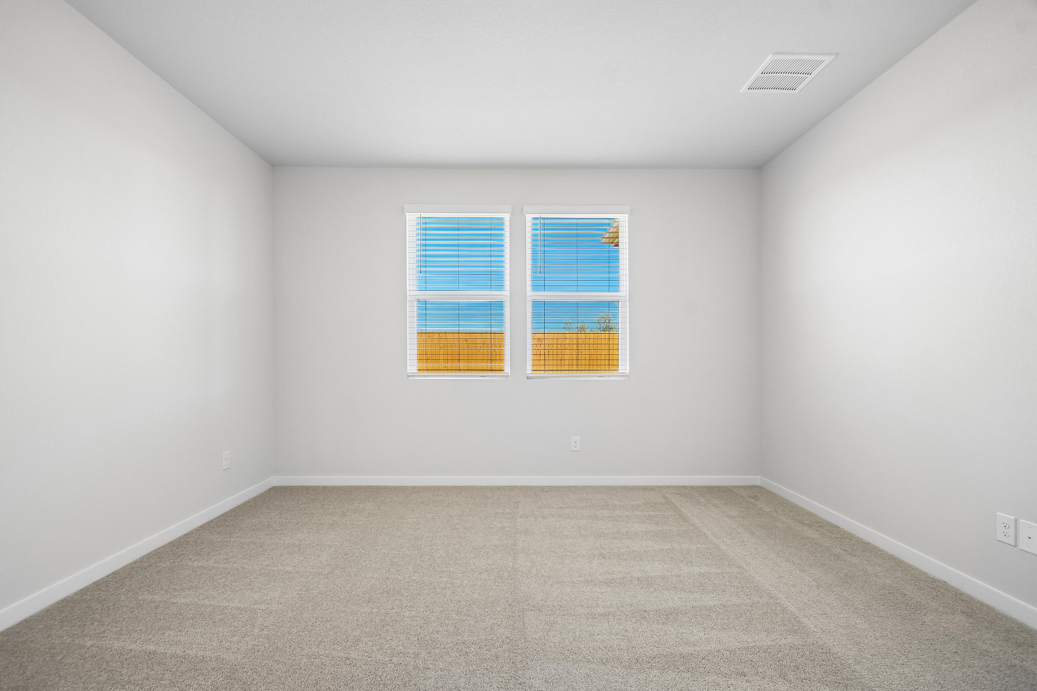 A room with a window and a carpet.