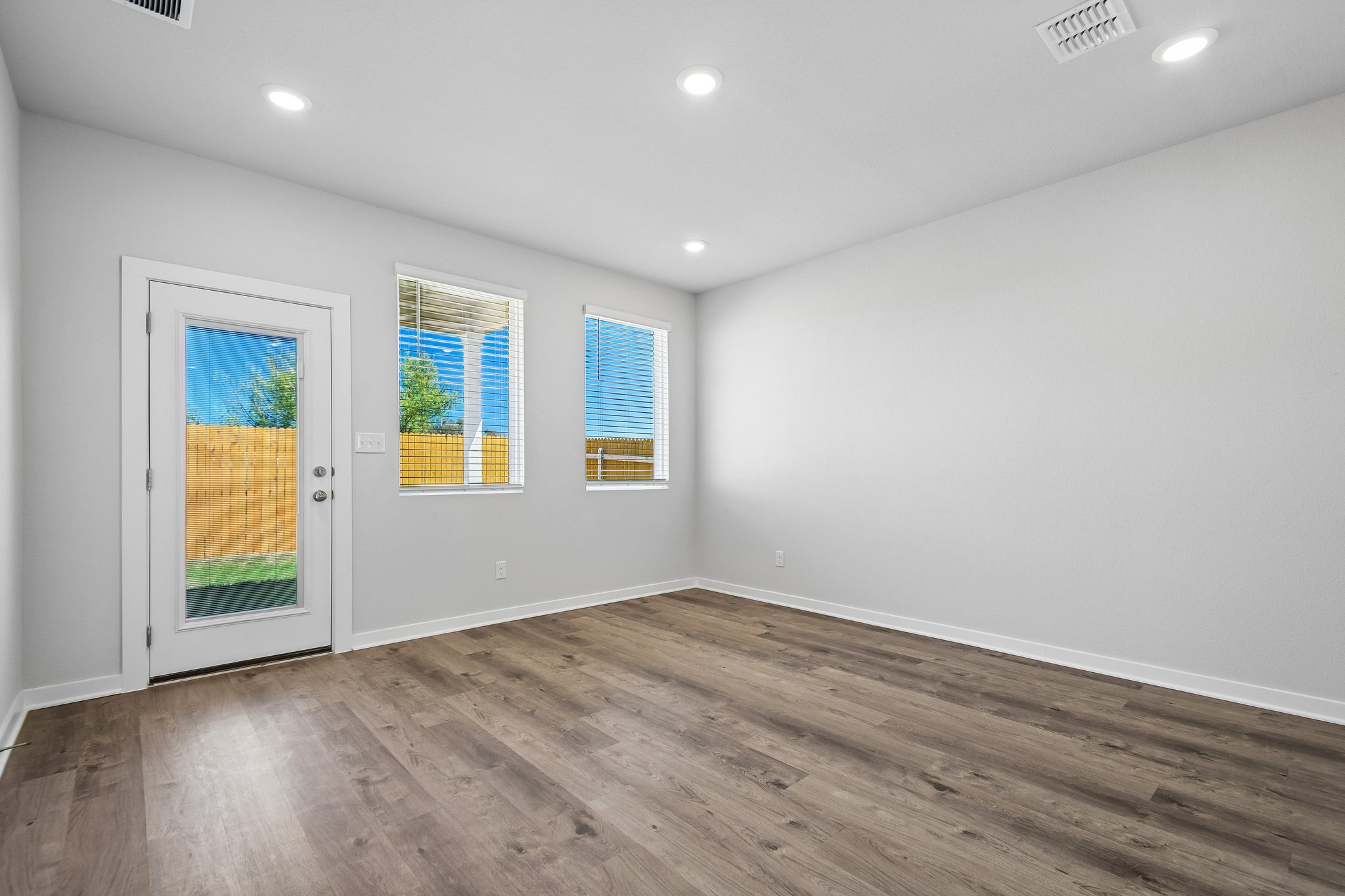 A room with a wood floor and windows.