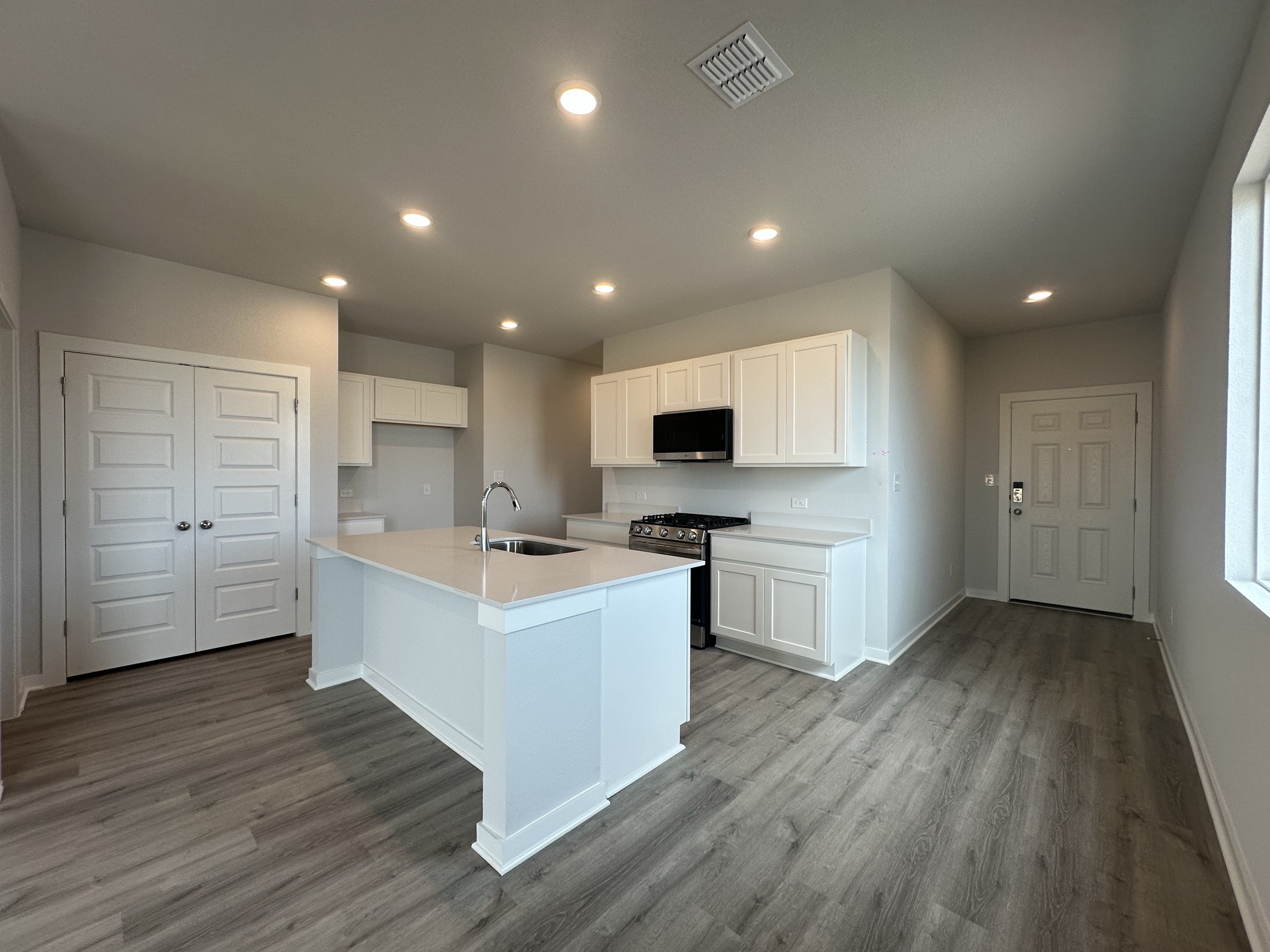 A kitchen with white cabinets.